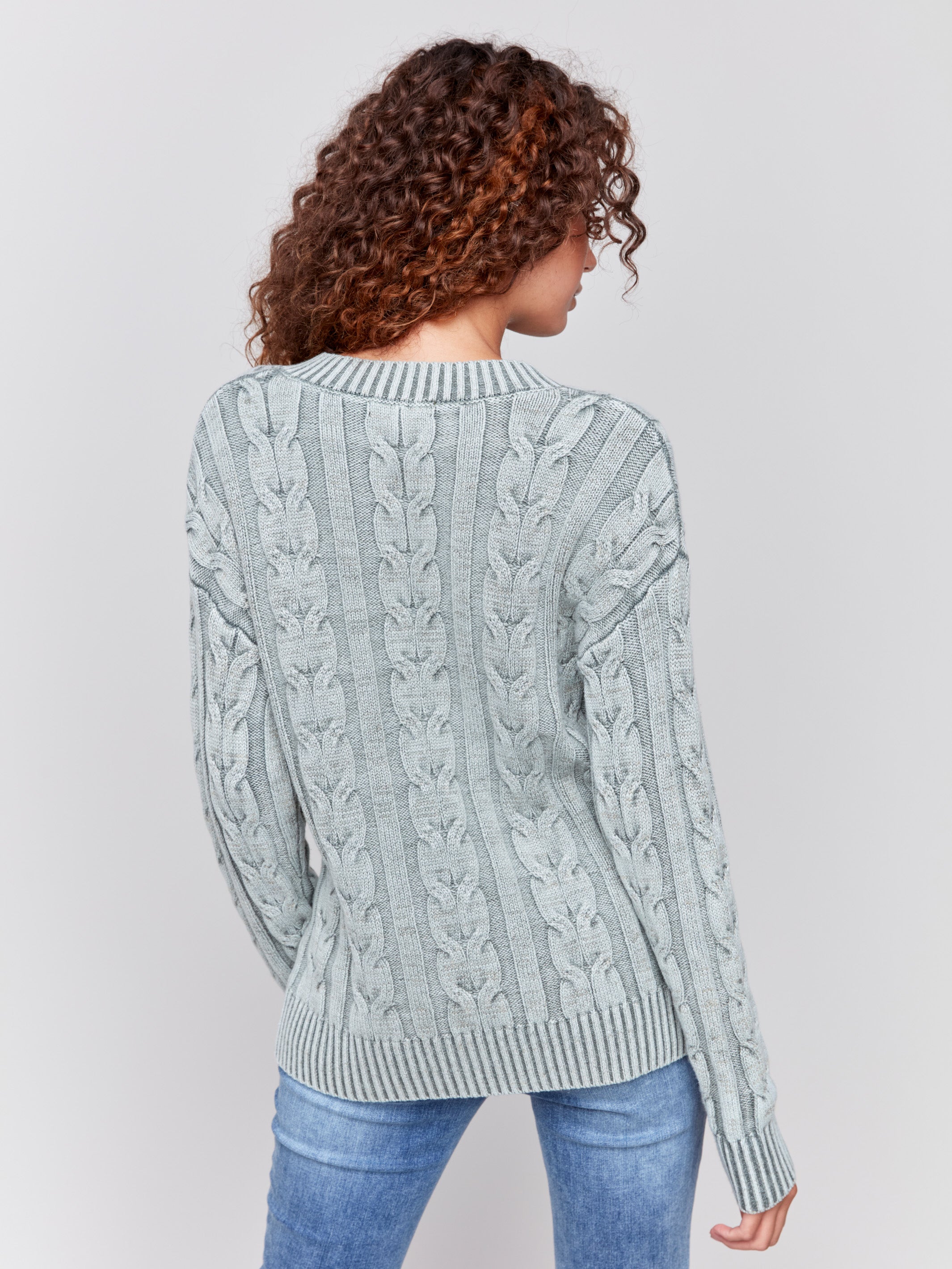 Spruce green cable knit sweater with a V-neckline, long sleeves, and geometric patterns by Charlie B.