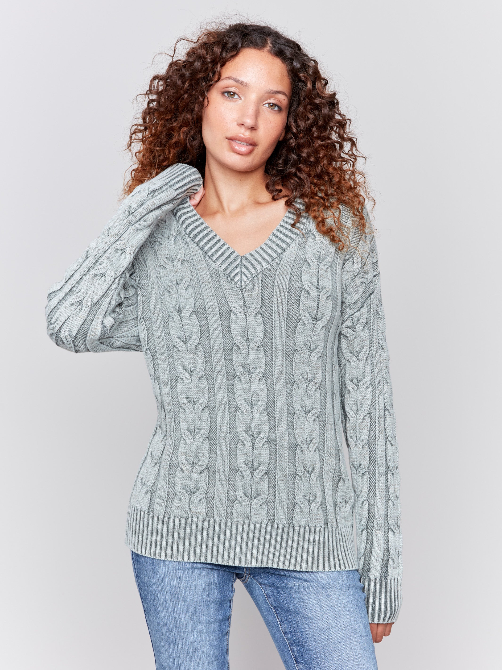 Spruce green cable knit sweater with a V-neckline, long sleeves, and geometric patterns by Charlie B.