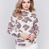 Woman wearing a beige mock neck sweater with a brown animal print by Charlie B.