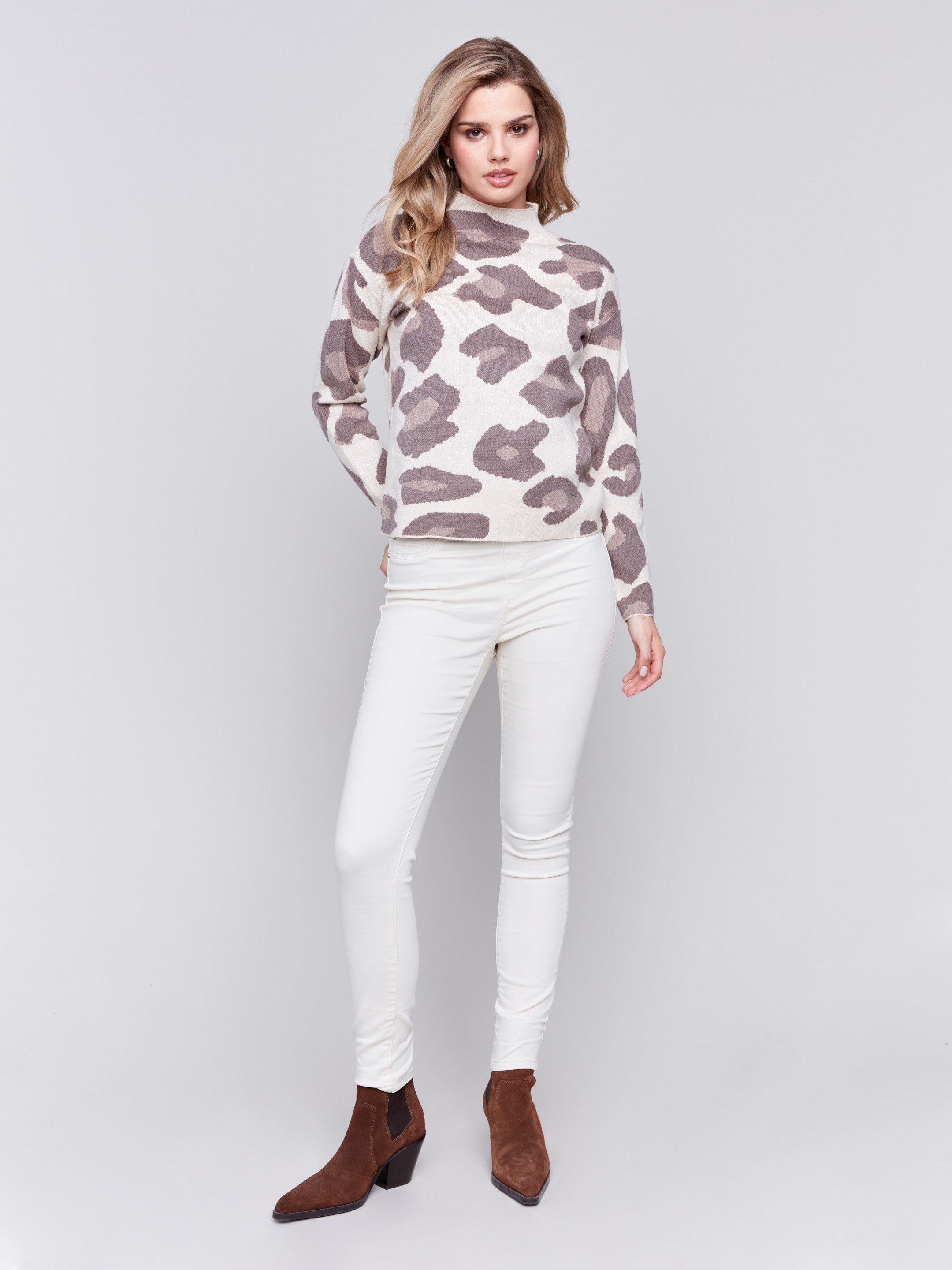 Woman wearing a beige mock neck sweater with a brown animal print by Charlie B.