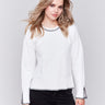 Cream white sweater featuring blanket stitch detailing along the crew neckline, cuffs, and hem, by Charlie B.