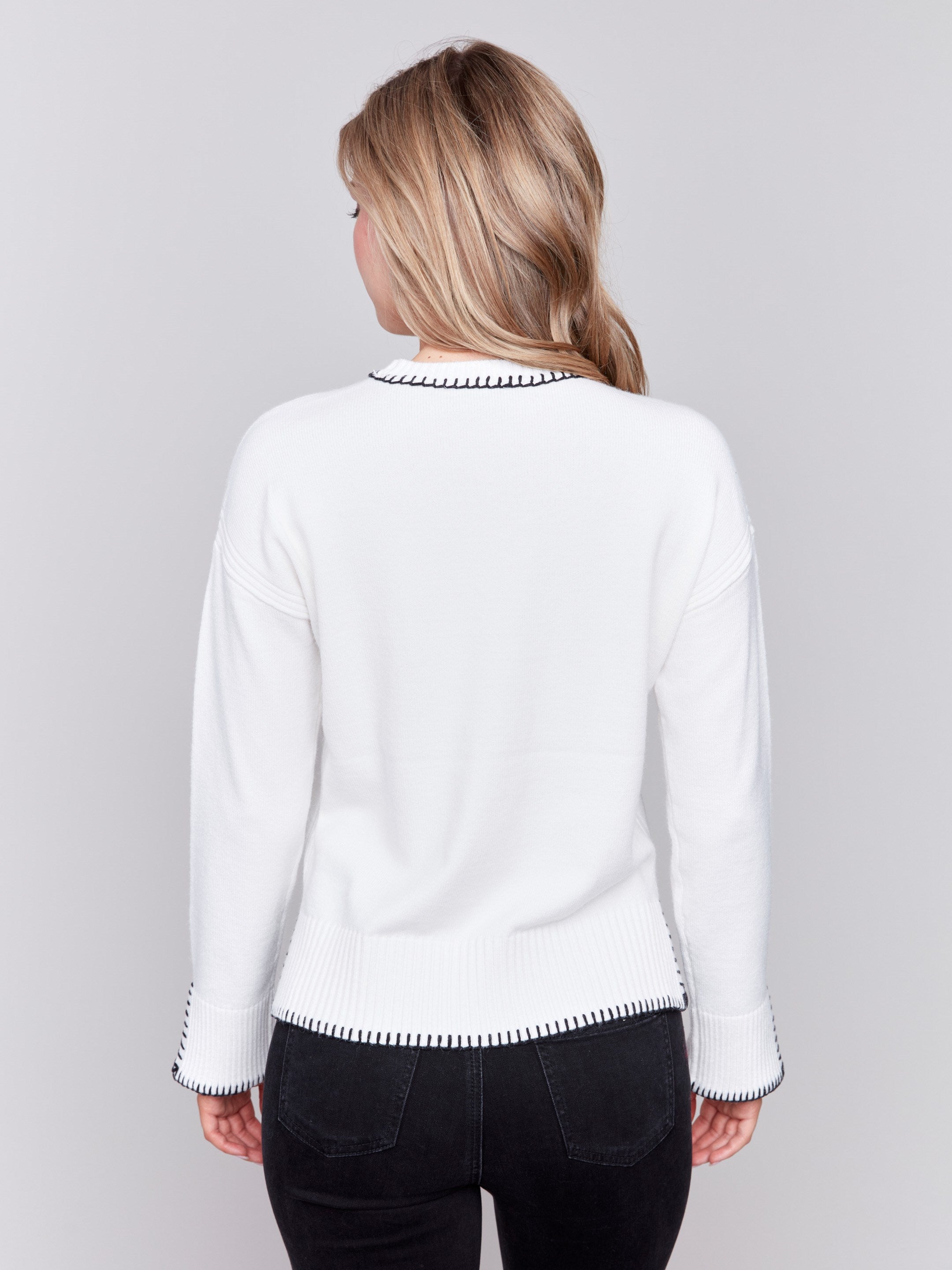 Cream white sweater featuring blanket stitch detailing along the crew neckline, cuffs, and hem, by Charlie B.