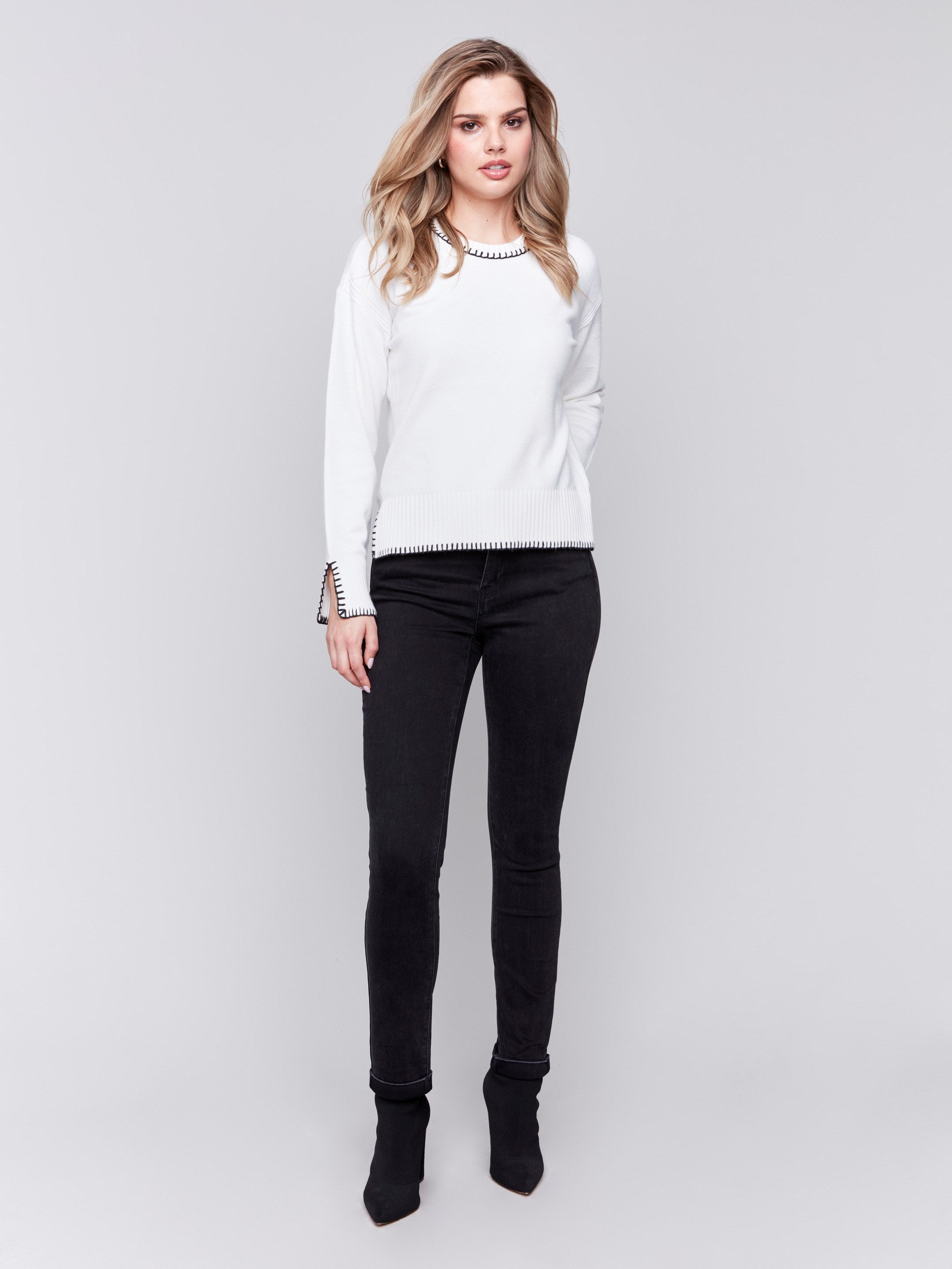 Cream white sweater featuring blanket stitch detailing along the crew neckline, cuffs, and hem, by Charlie B.