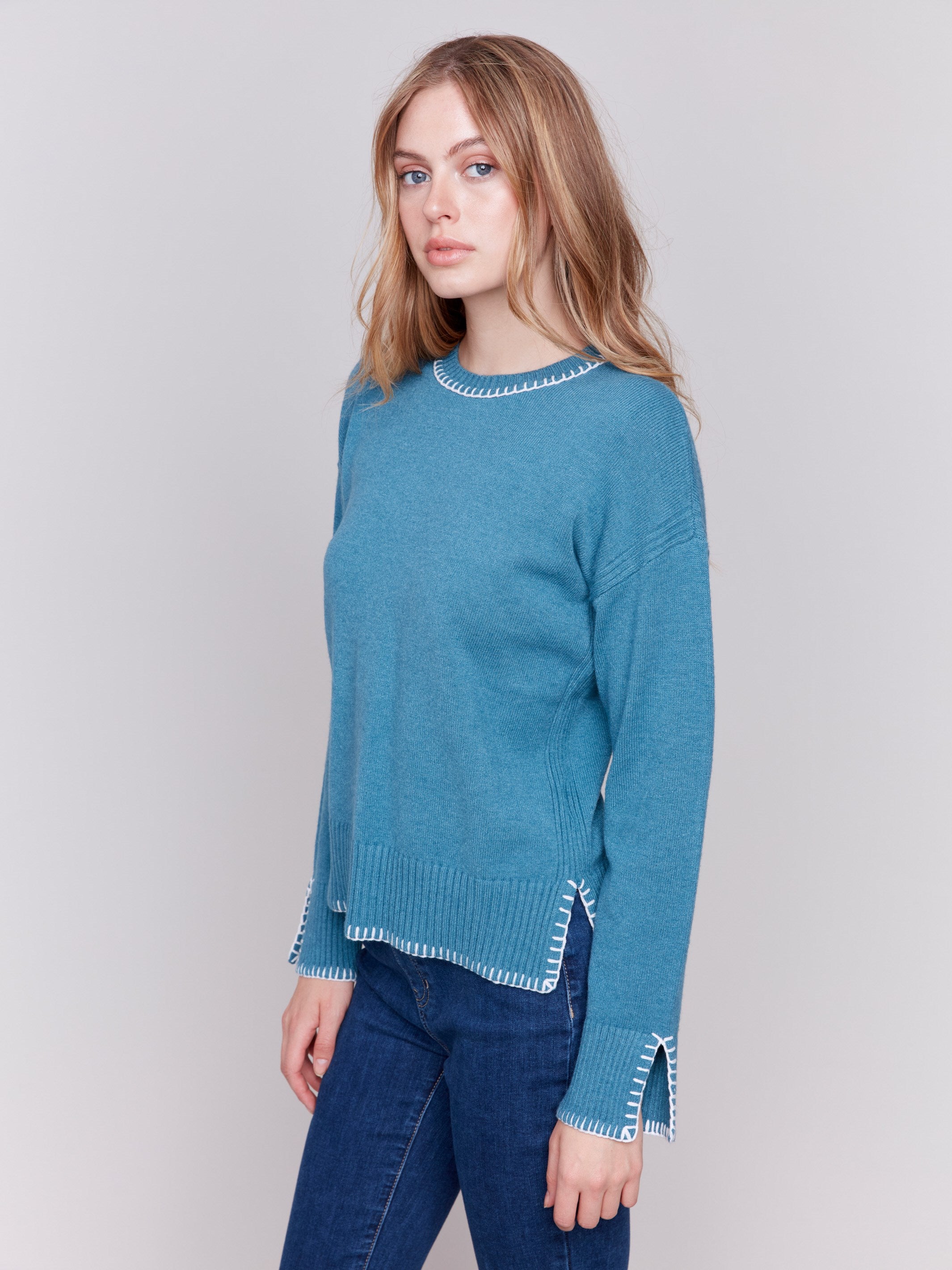 Peacock blue sweater featuring blanket stitch detailing along the crew neckline, cuffs, and hem, by Charlie B.