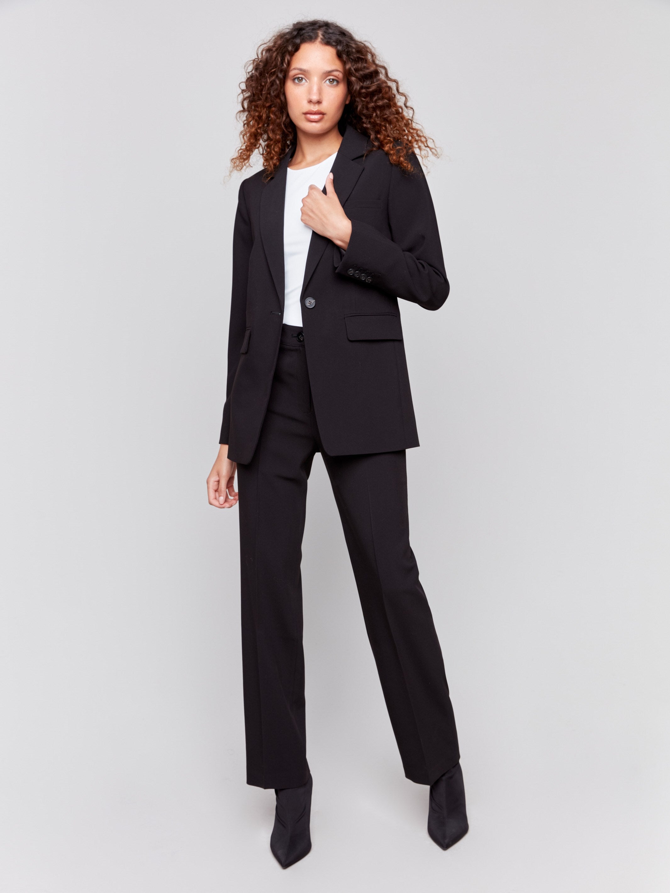 Black blazer featuring a ruched back detail, single button closure, and front flap pockets by Charlie B.