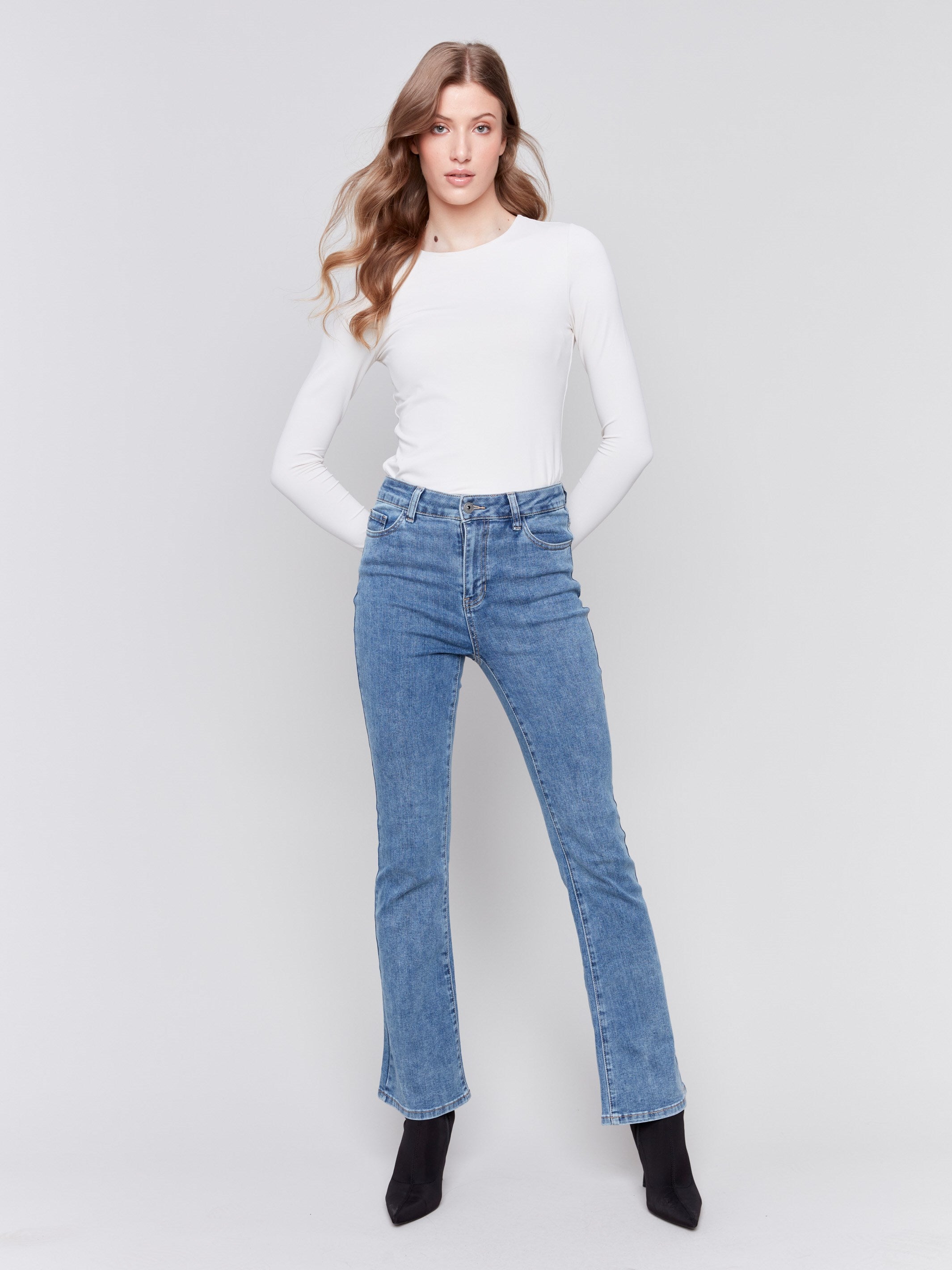 Medium blue bootcut jeans featuring a classic five-pocket design and button closure by Charlie B.