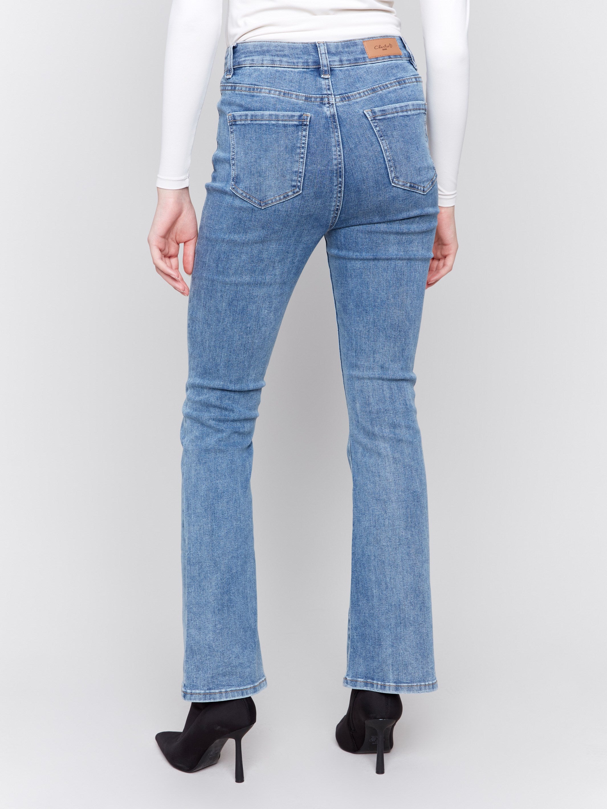 Medium blue bootcut jeans featuring a classic five-pocket design and button closure by Charlie B.