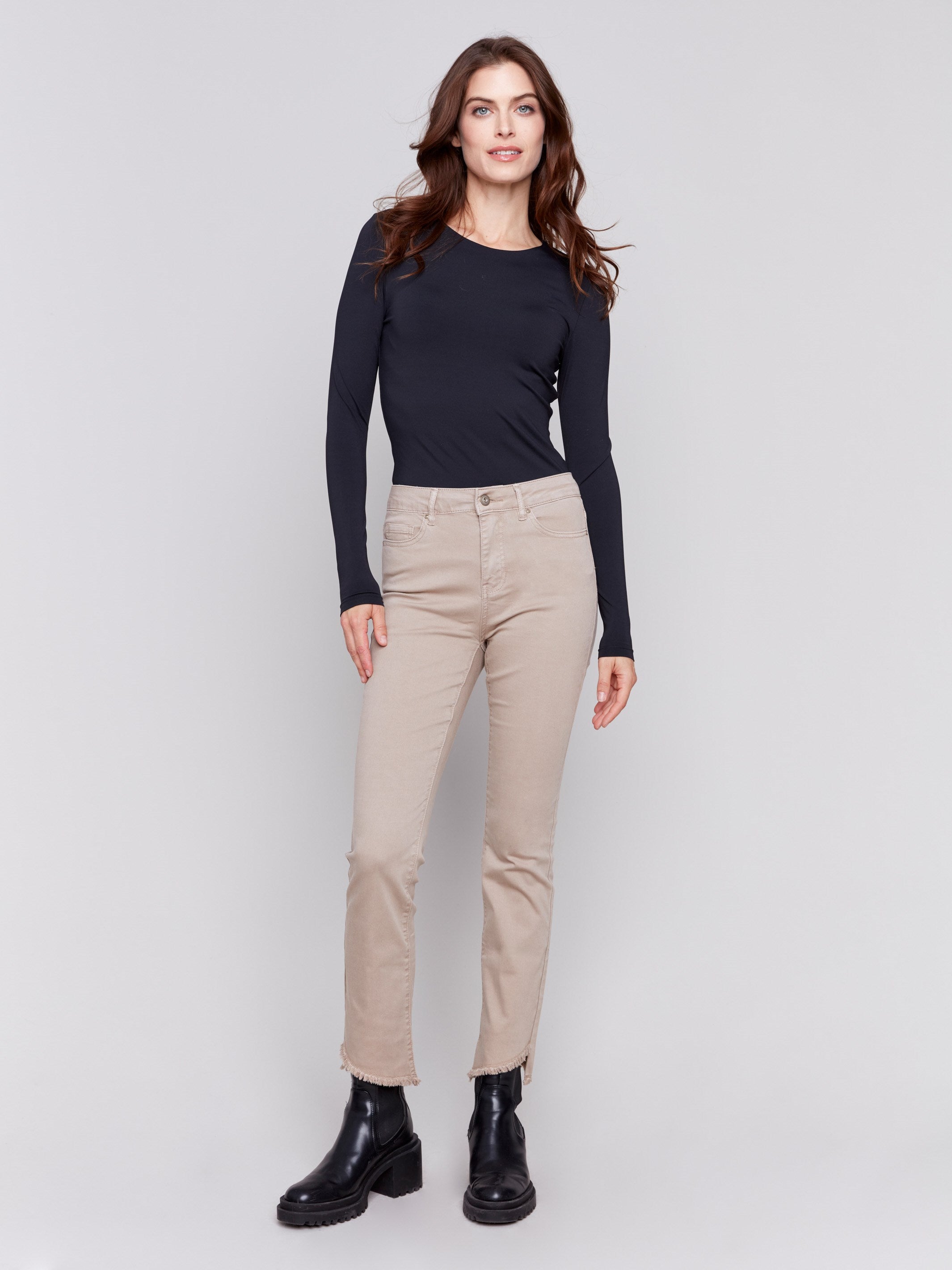 Almond beige bootcut twill pants with an asymmetrical fringe hem and mid-rise waist by Charlie B.