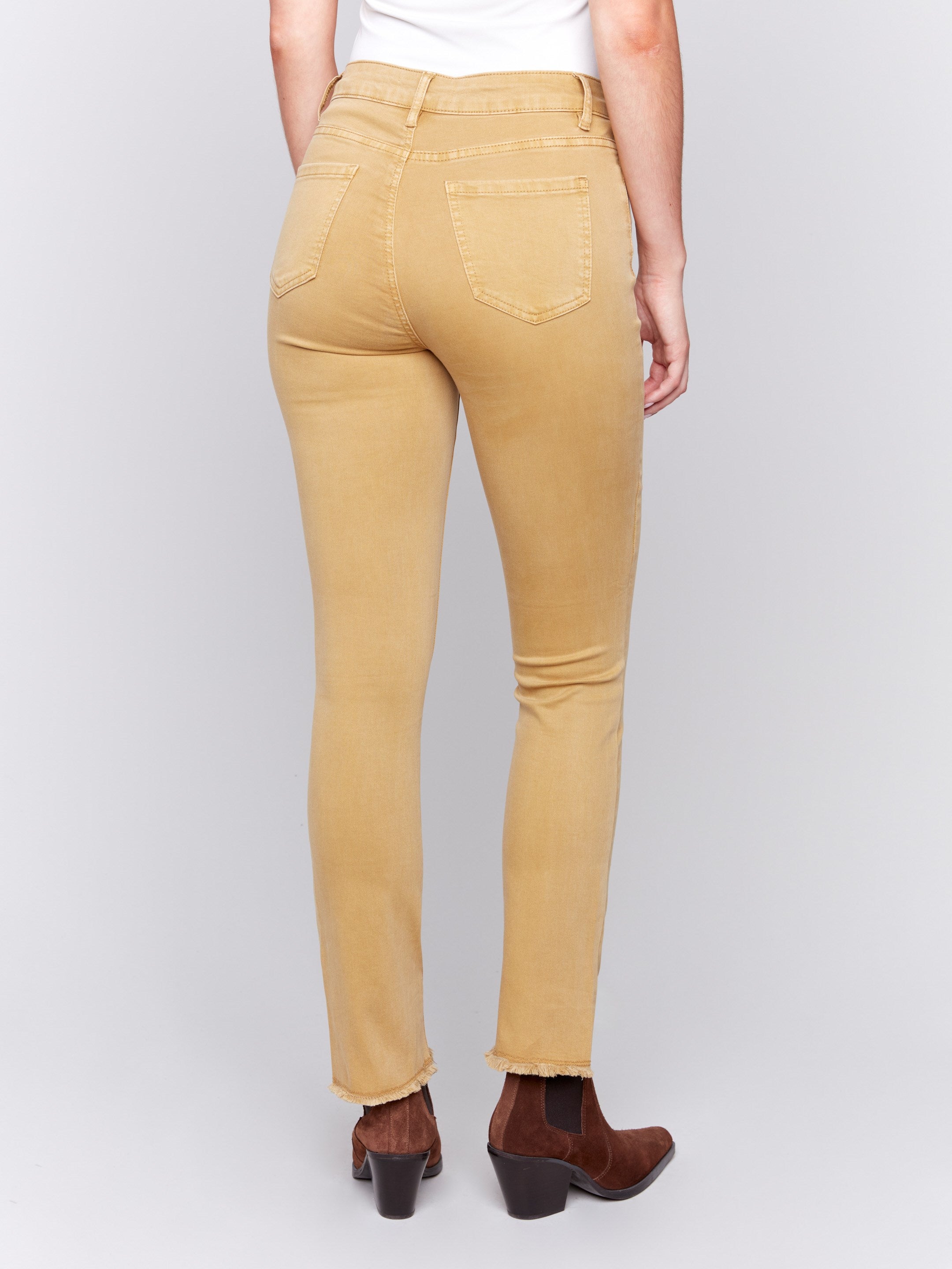 Amber yellow bootcut twill pants with an asymmetrical fringe hem and mid-rise waist by Charlie B.