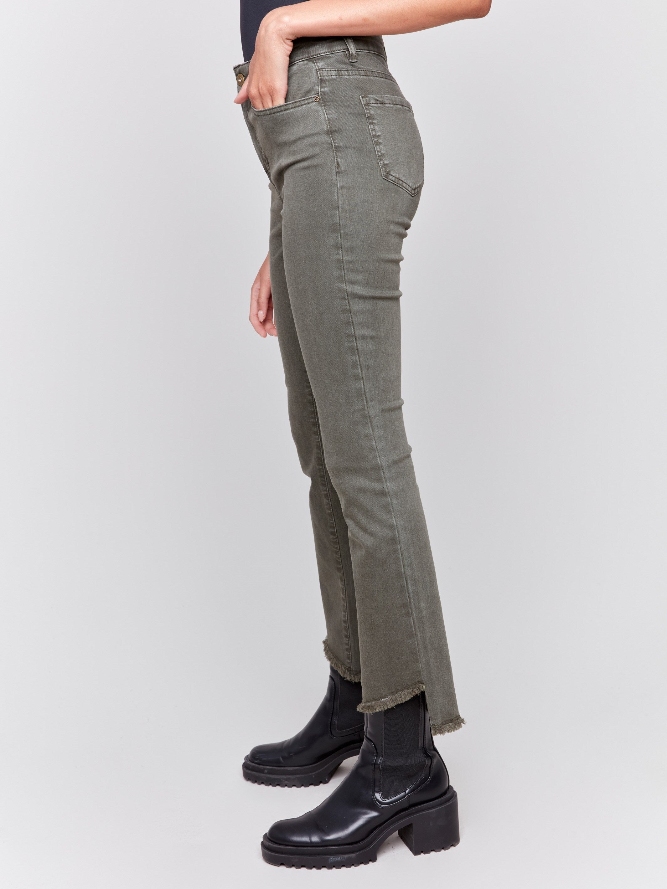 Spruce green bootcut twill pants with an asymmetrical fringe hem and mid-rise waist by Charlie B.