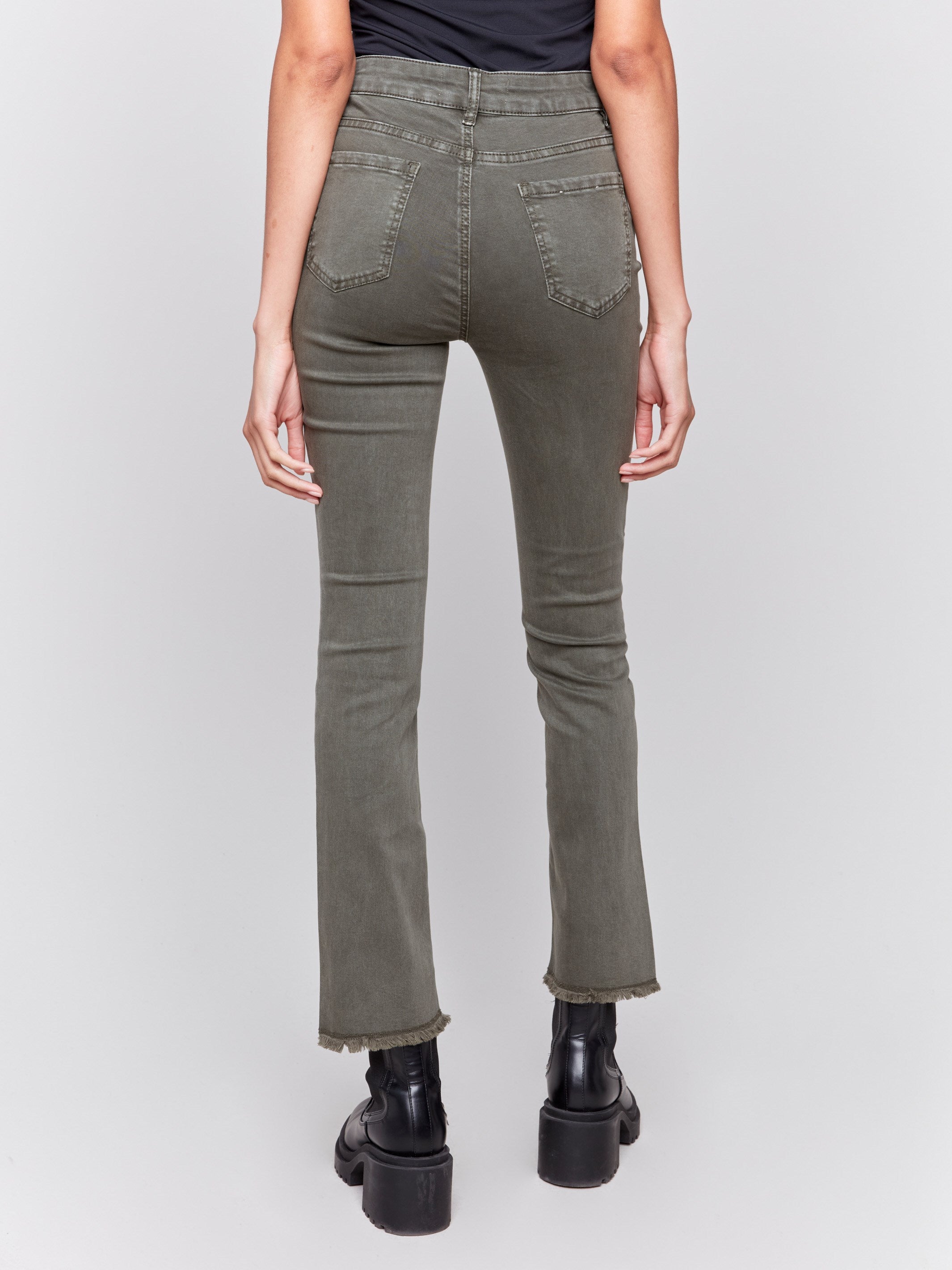 Spruce green bootcut twill pants with an asymmetrical fringe hem and mid-rise waist by Charlie B.