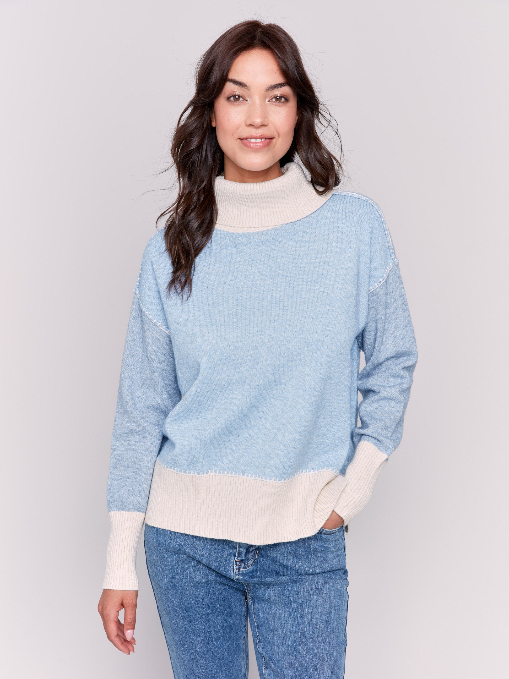 Light blue turtleneck sweater with color block design, featuring long sleeves and ribbed cuffs by Charlie B.