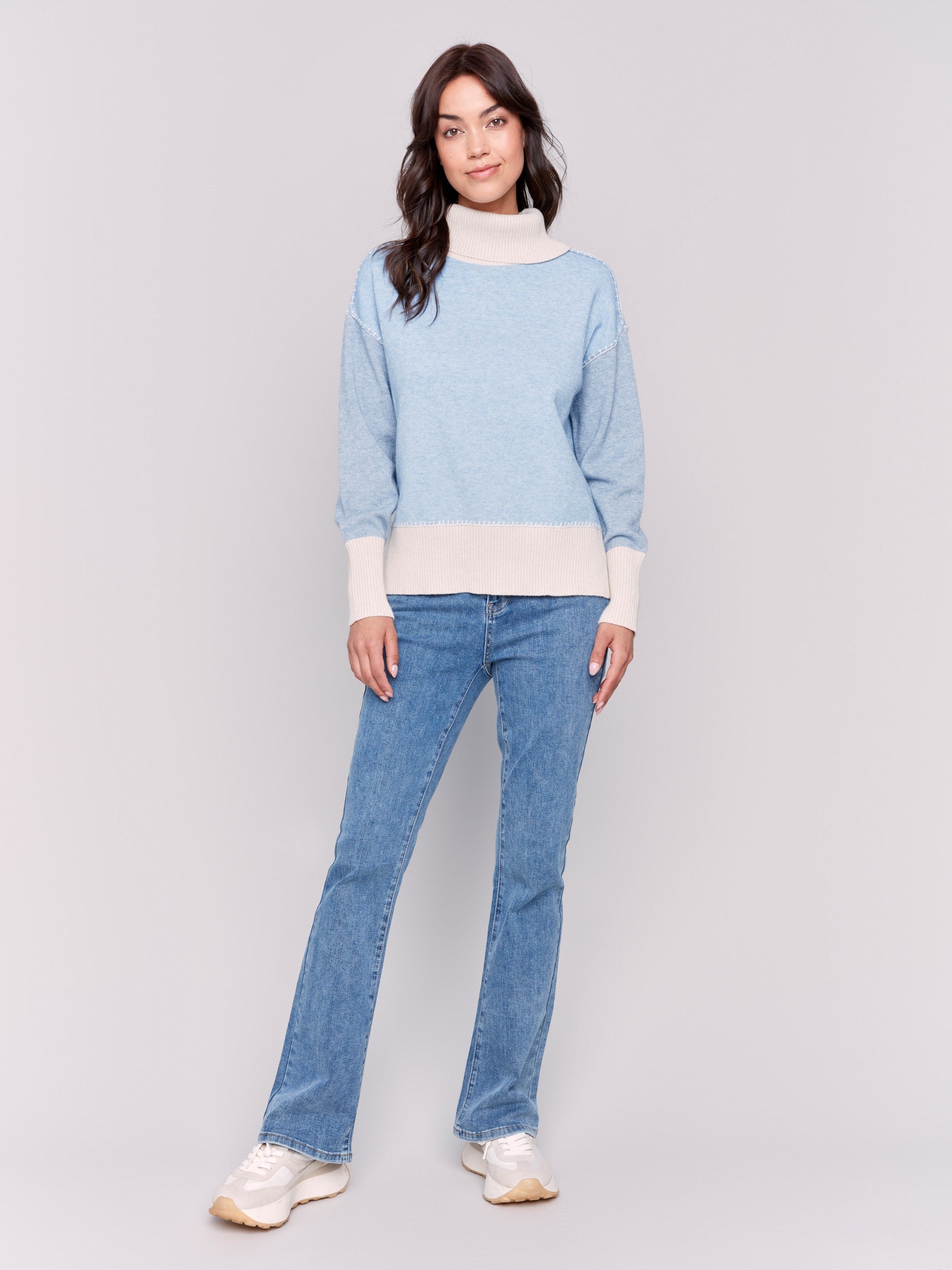 Light blue turtleneck sweater with color block design, featuring long sleeves and ribbed cuffs by Charlie B.