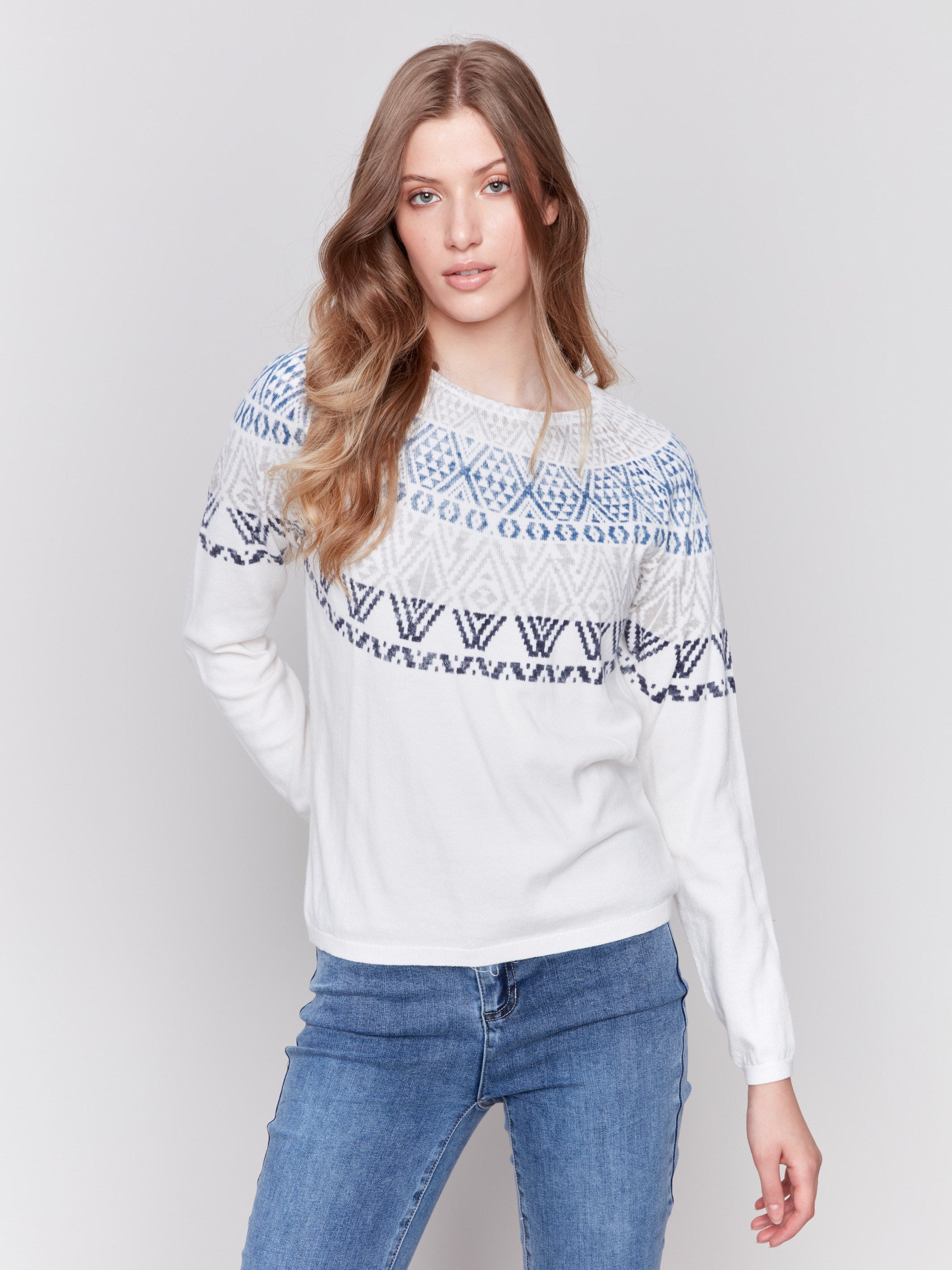 Light ecru ski sweater with geometric patterns across the chest and shoulders, featuring long sleeves and a crew neckline by Charlie B.