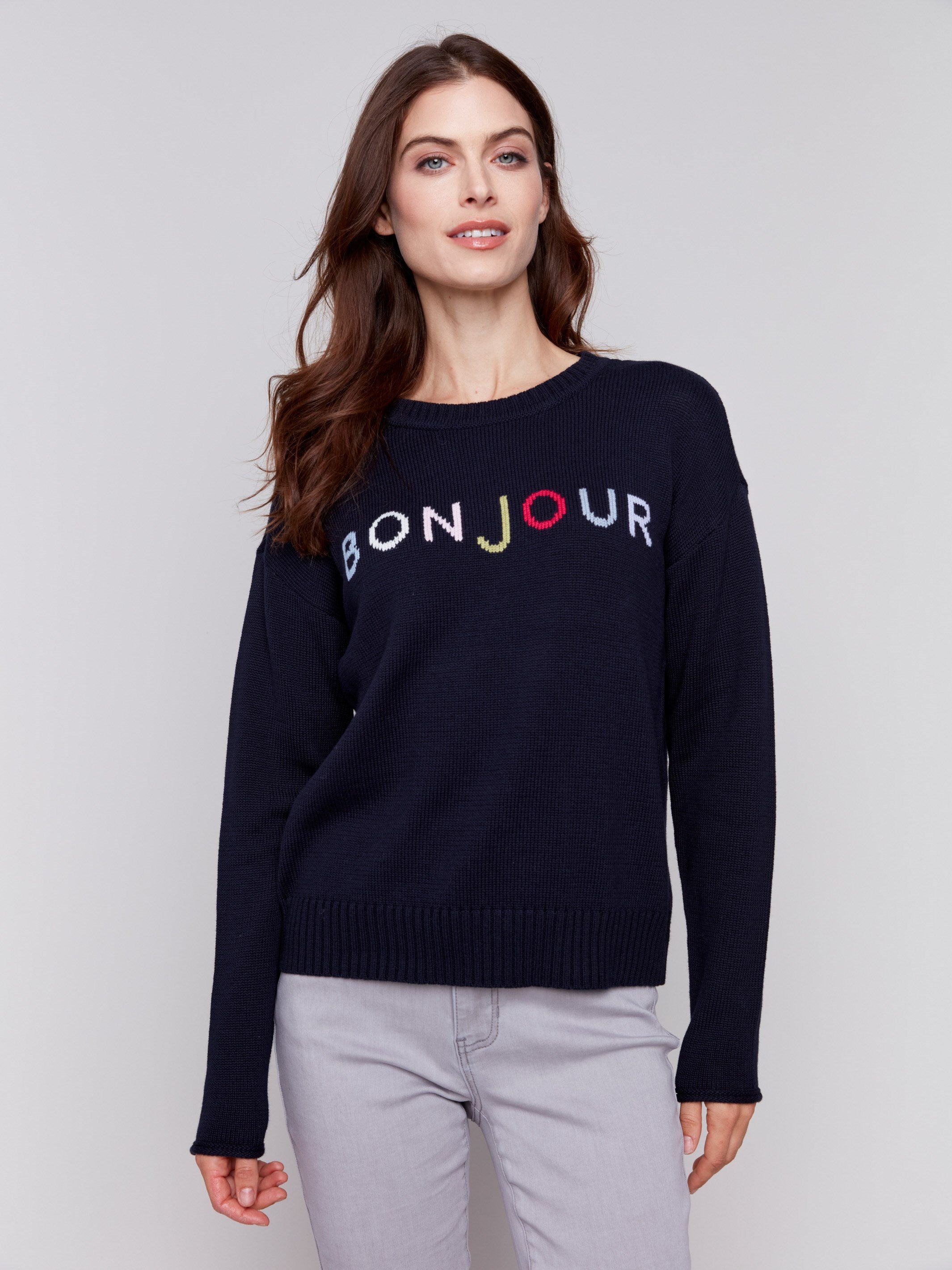 Navy sweater with colorful 'Bonjour' letters embroidered on the chest, featuring long sleeves and a crew neckline by Charlie B.