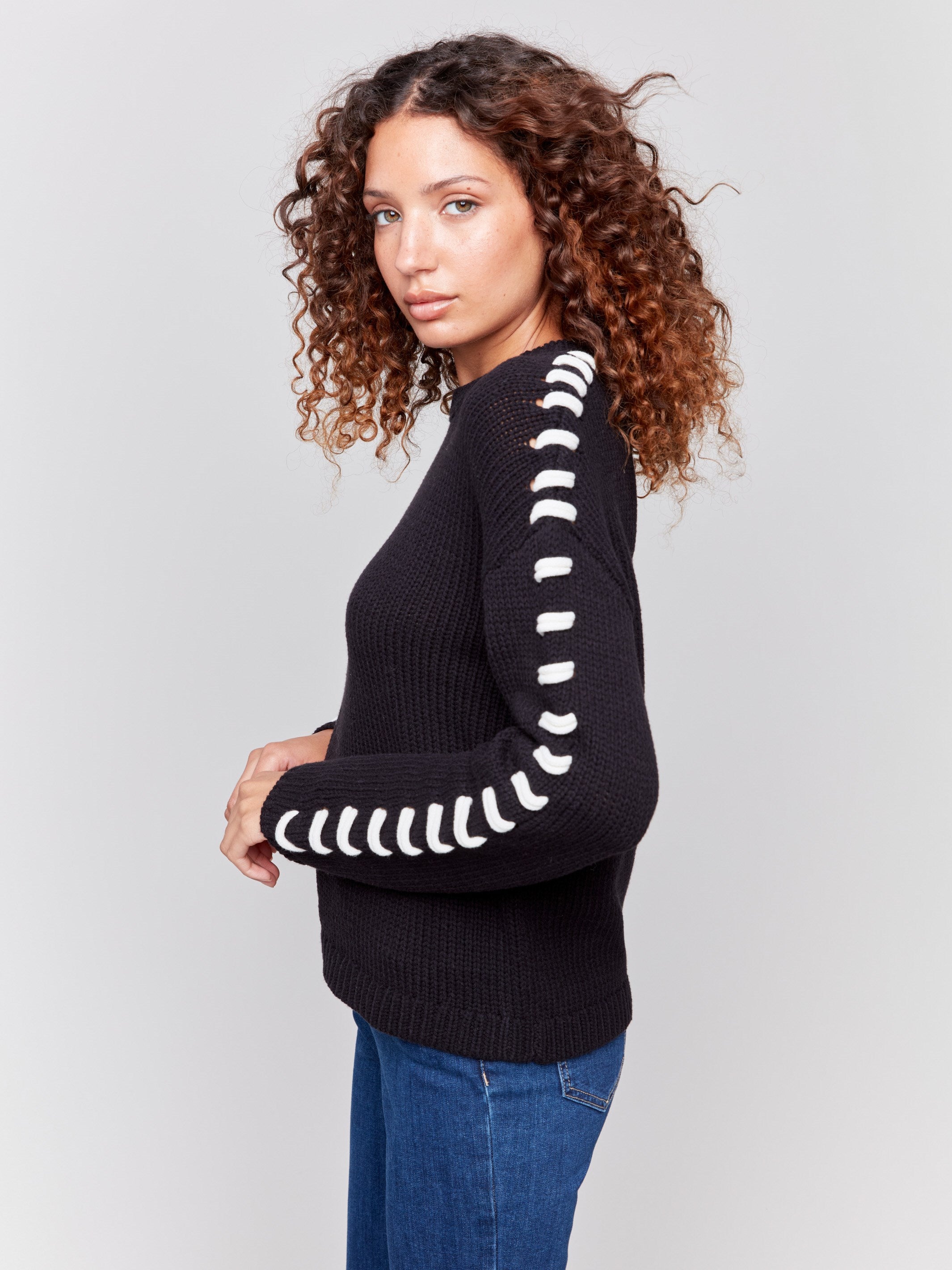 Black cotton blend sweater with white stitch detailing along the shoulders and a crew neckline by Charlie B.