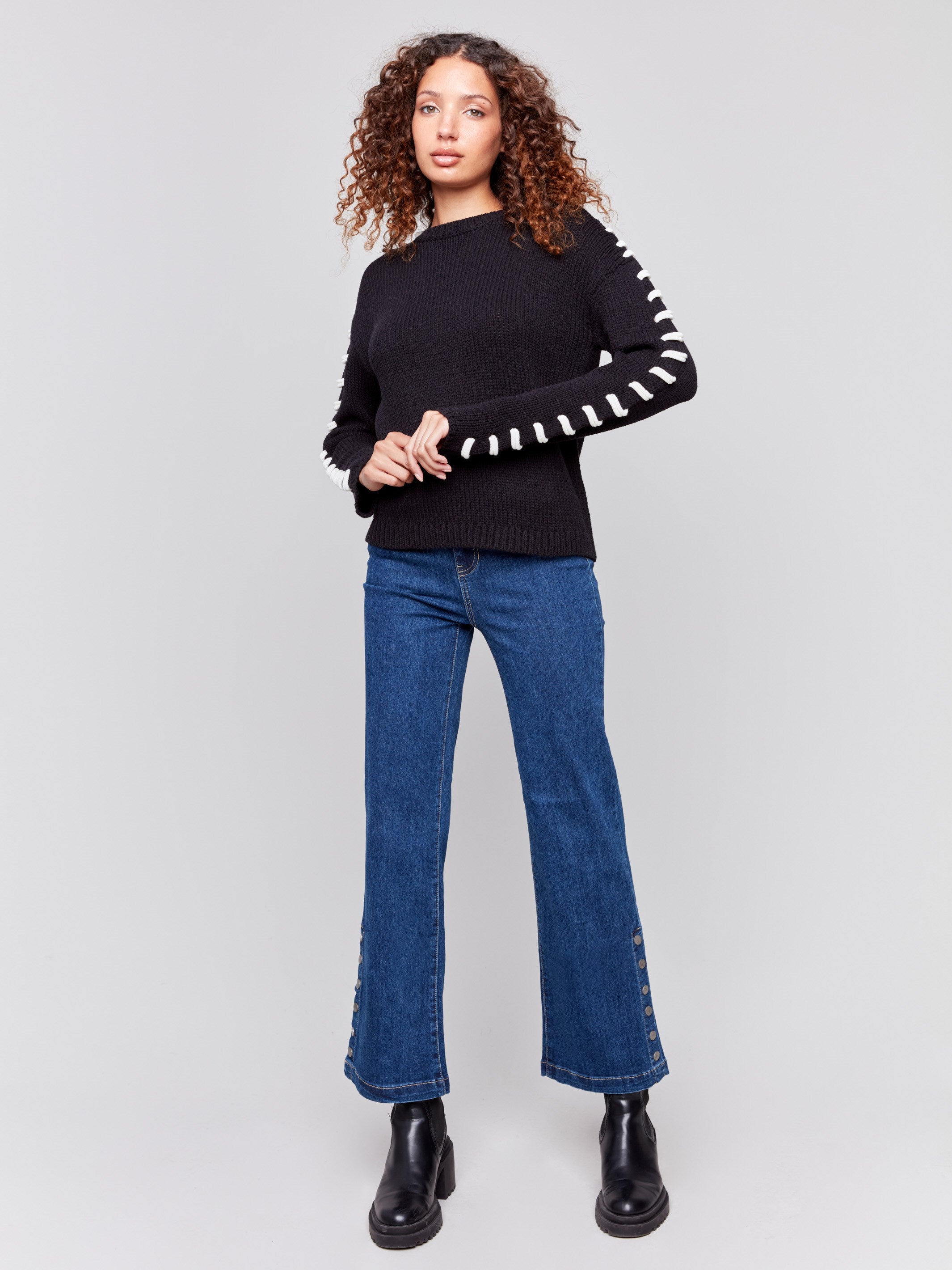 Black cotton blend sweater with white stitch detailing along the shoulders and a crew neckline by Charlie B.