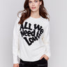 Ecru white crew neck sweater with black 'All We Need is Love' embroidery, featuring a drop shoulder design and long sleeves by Charlie B.