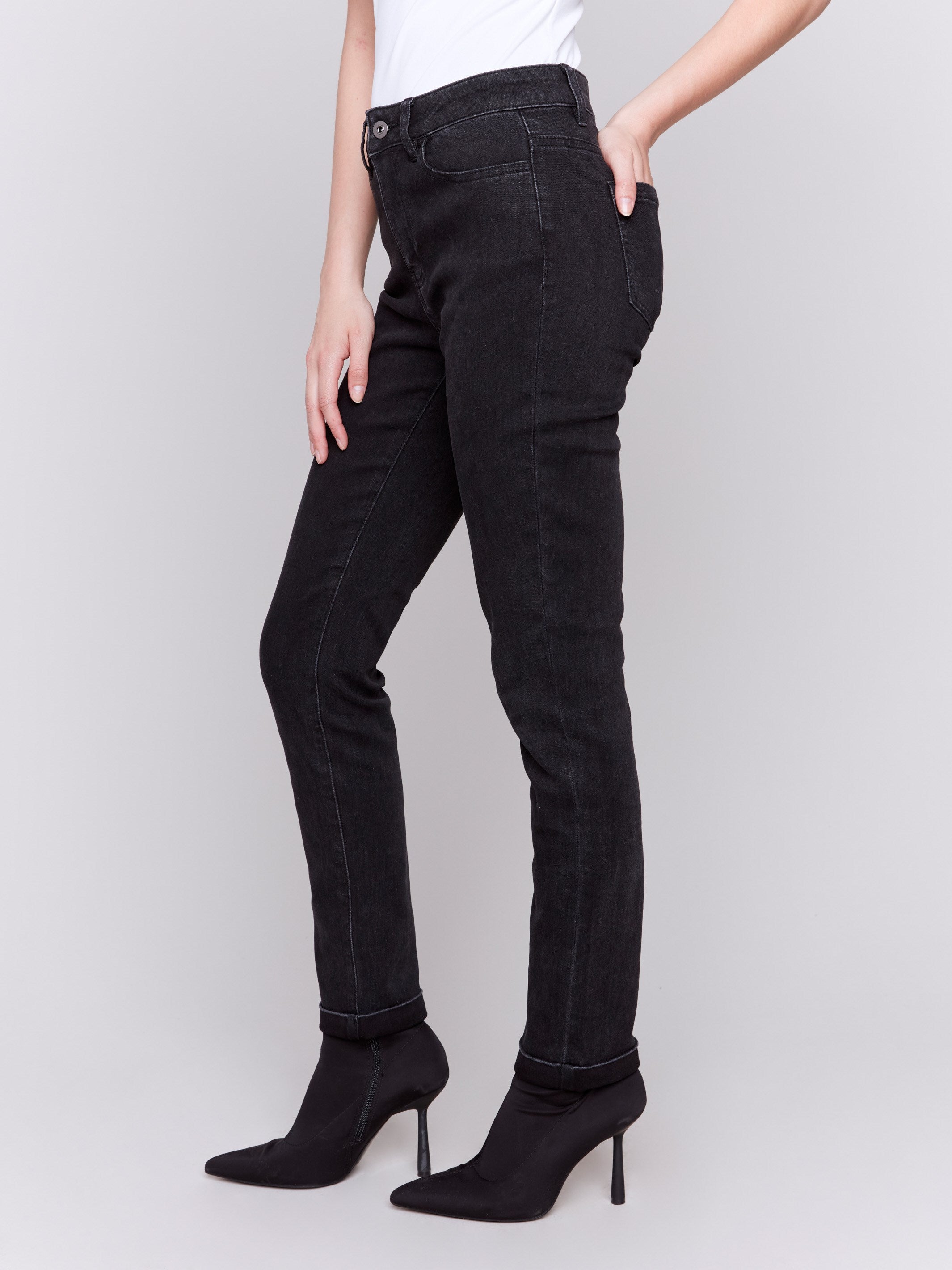 Charcoal black slim leg jeans with a cuffed hem, featuring a mid-rise and five-pocket design by Charlie B.