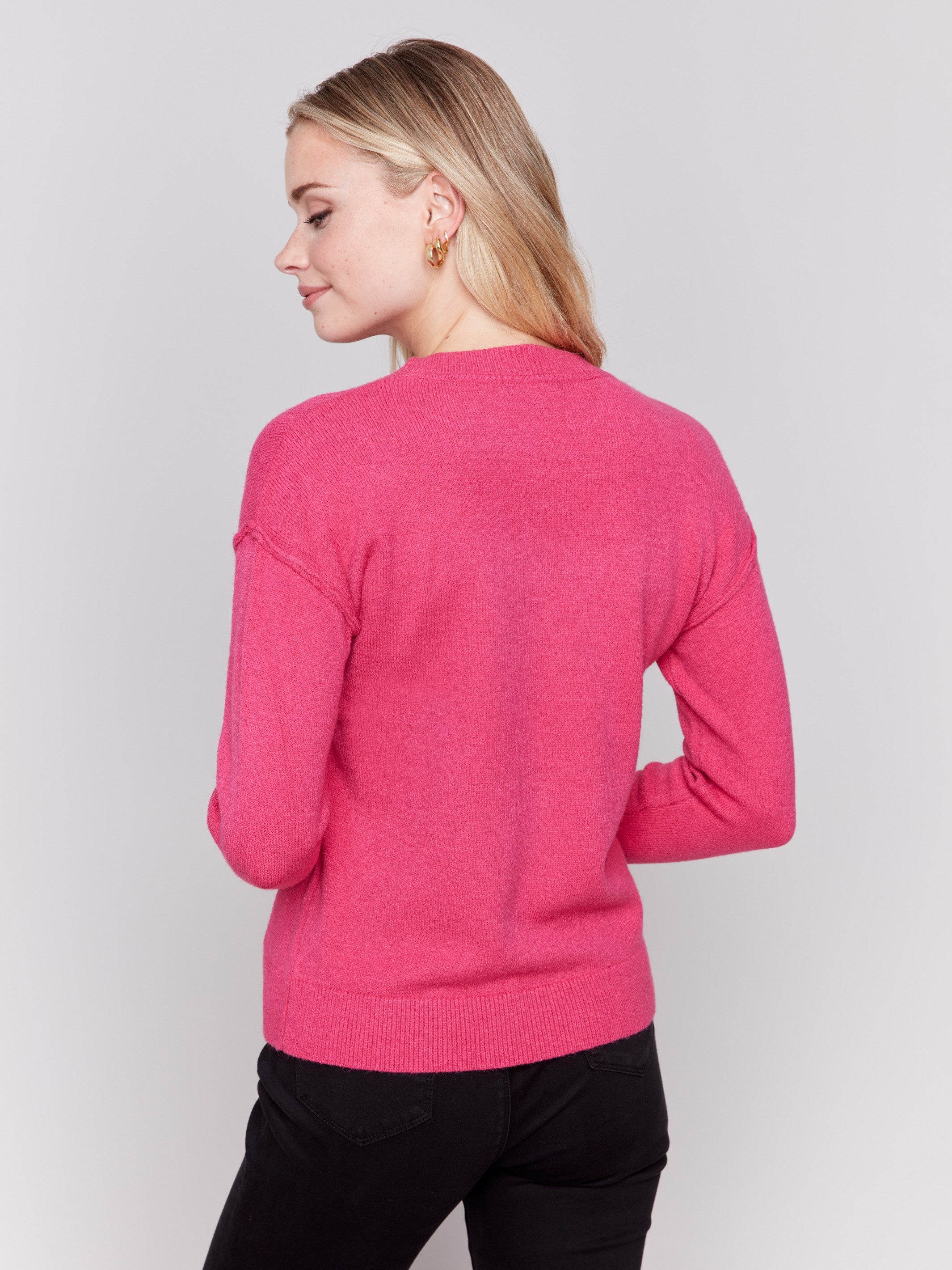 Magenta pink crew neck sweater featuring embroidered city names in black by Charlie B.