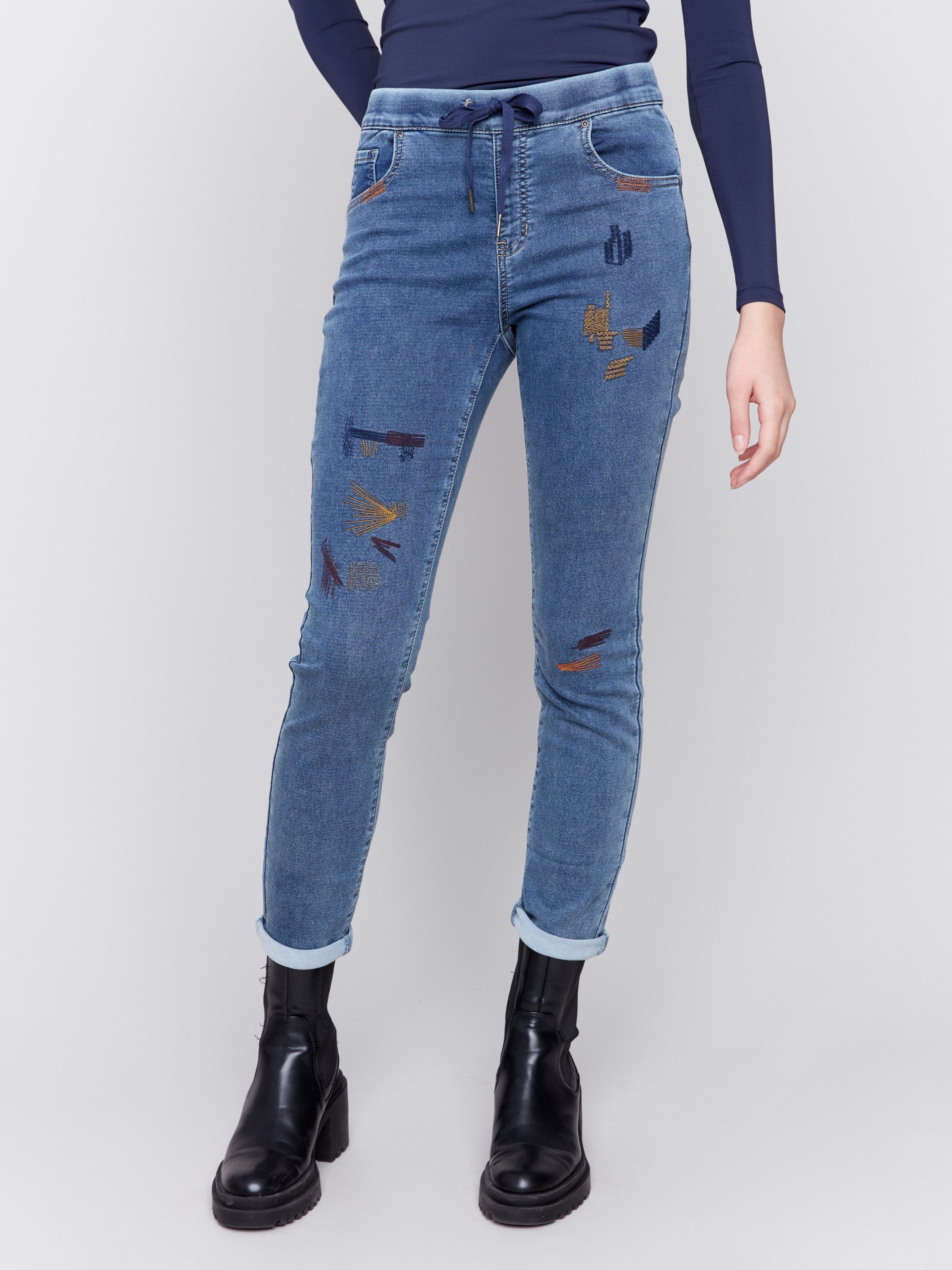 Medium blue embroidered knit denim jogger pants with elasticized waistband and slim leg by Charlie B.