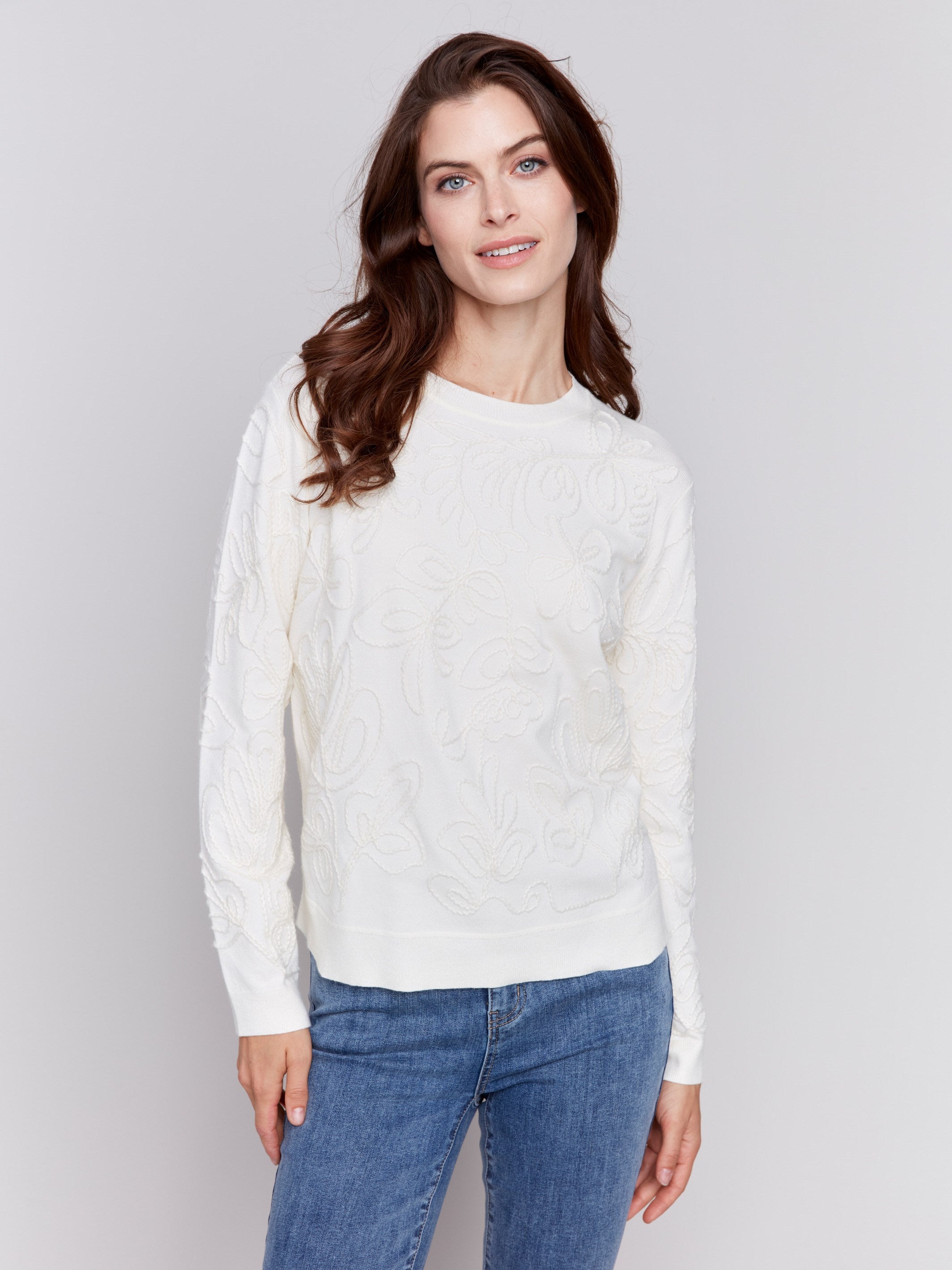 White sweater with floral embroidery, long sleeves, and a round neckline by Charlie B.