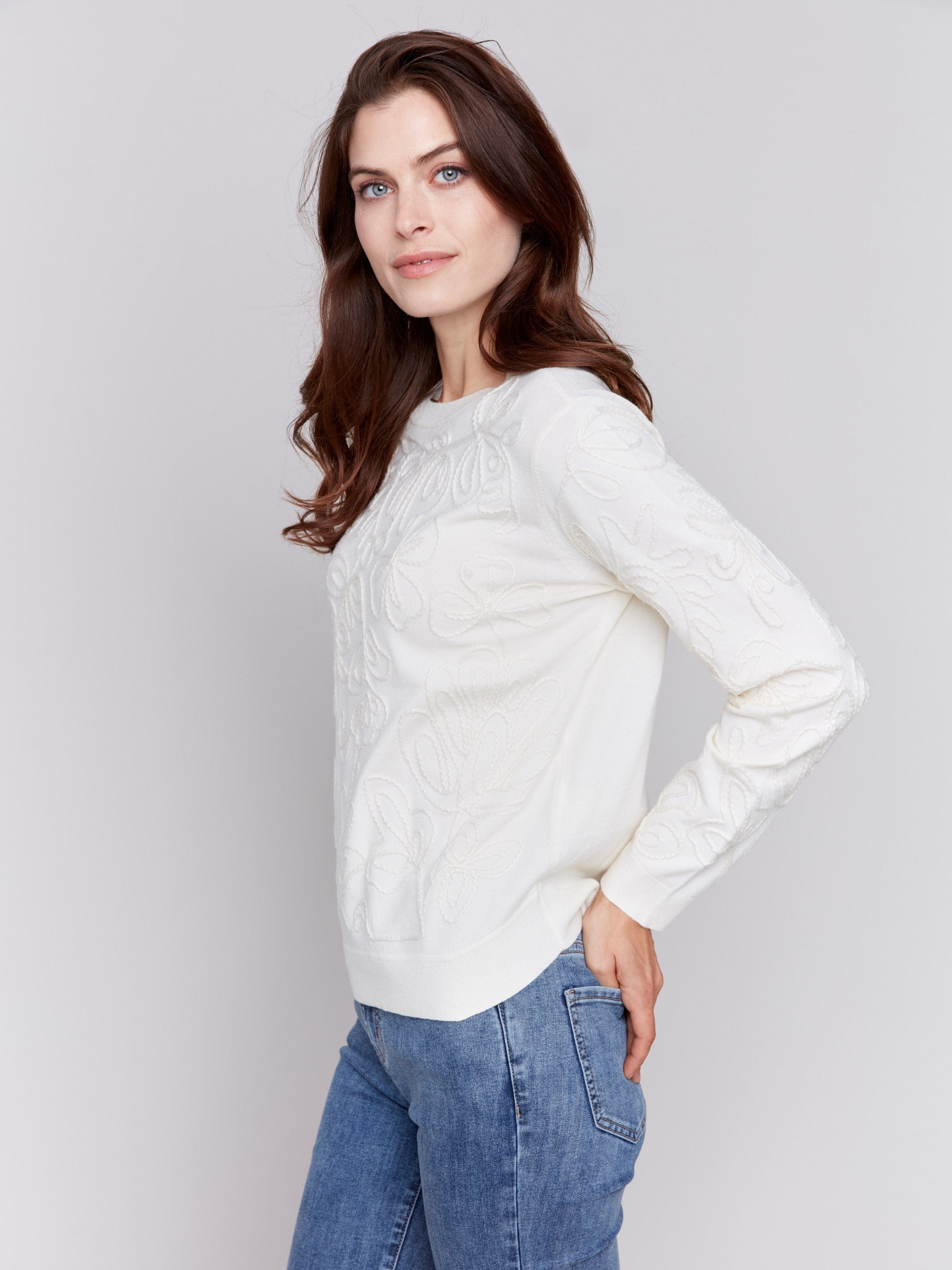 White sweater with floral embroidery, long sleeves, and a round neckline by Charlie B.