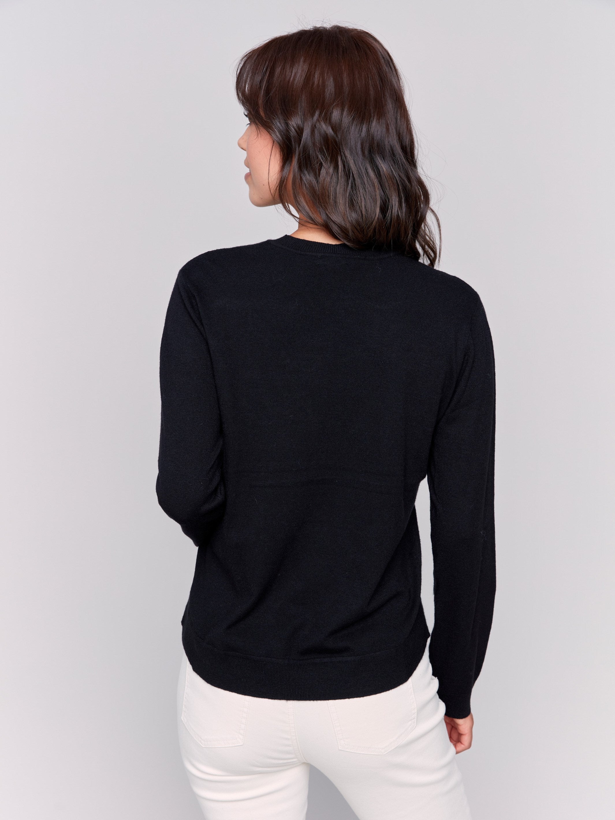 Black jacquard knit sweater featuring abstract embroidery and a round hemline by Charlie B.