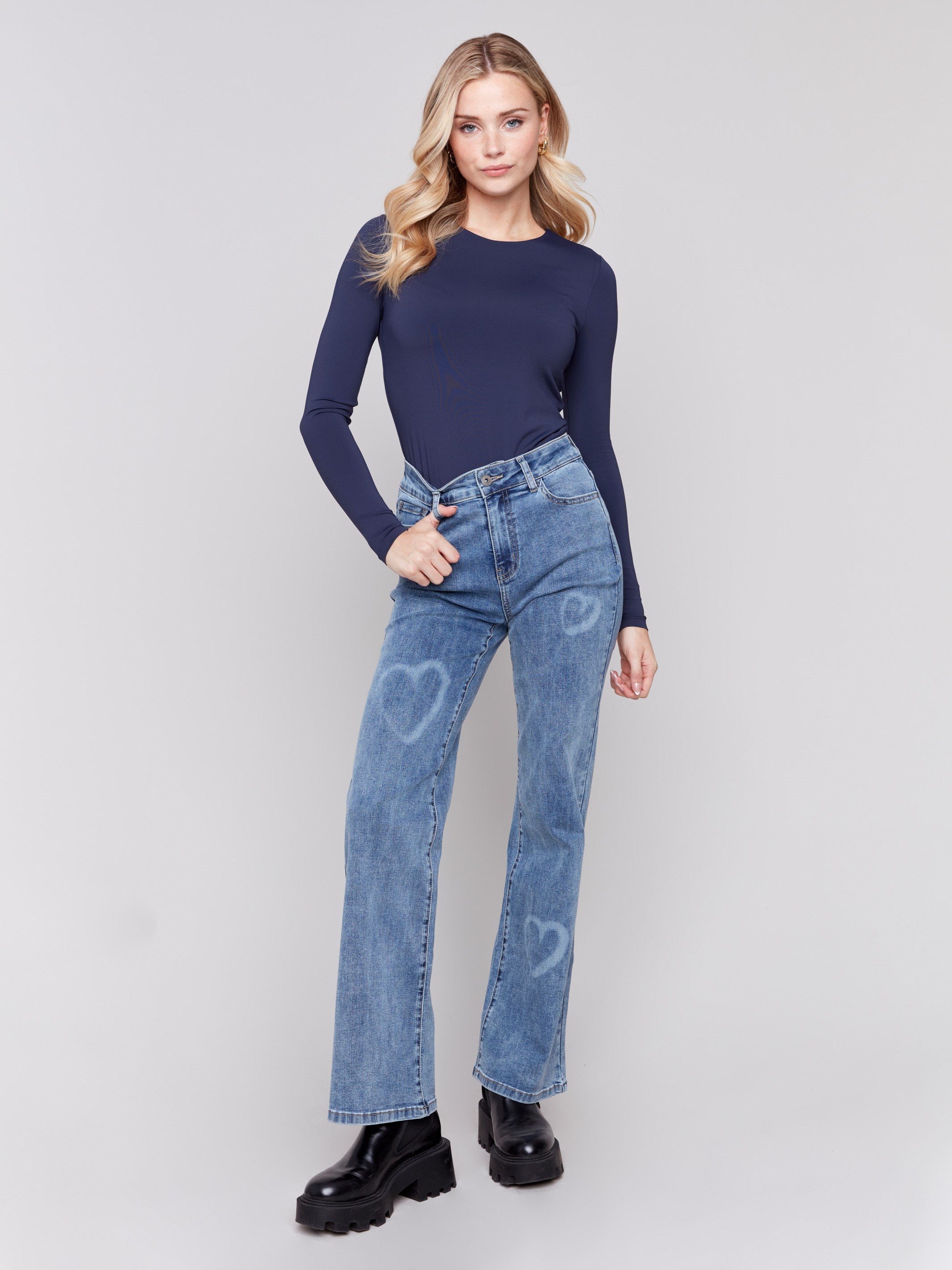 Medium blue flare jeans with laser-cut heart designs, regular rise, and flare leg by Charlie B.