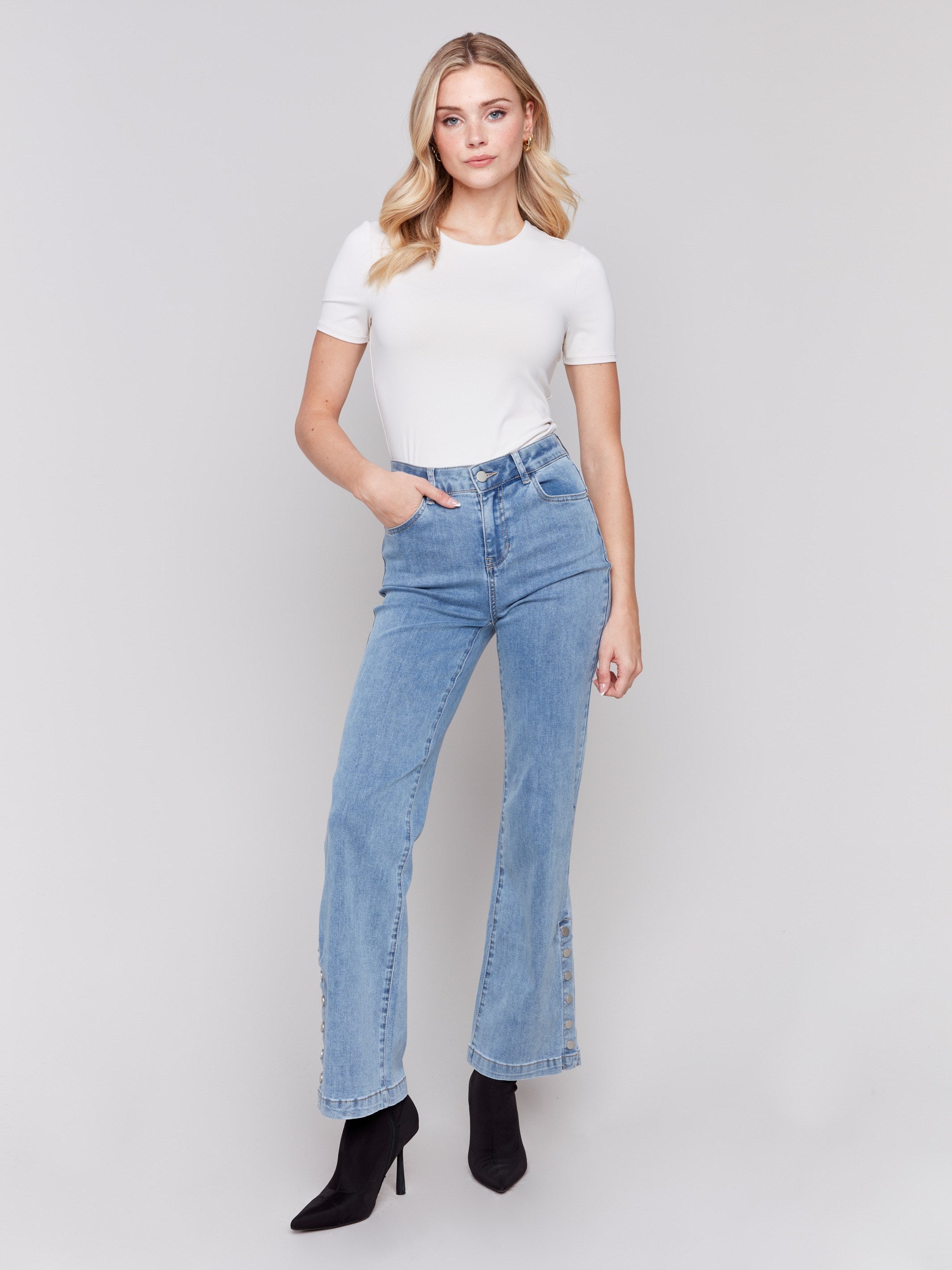 Light blue flare jeans with side button detailing, featuring a regular rise and classic five-pocket design by Charlie B.