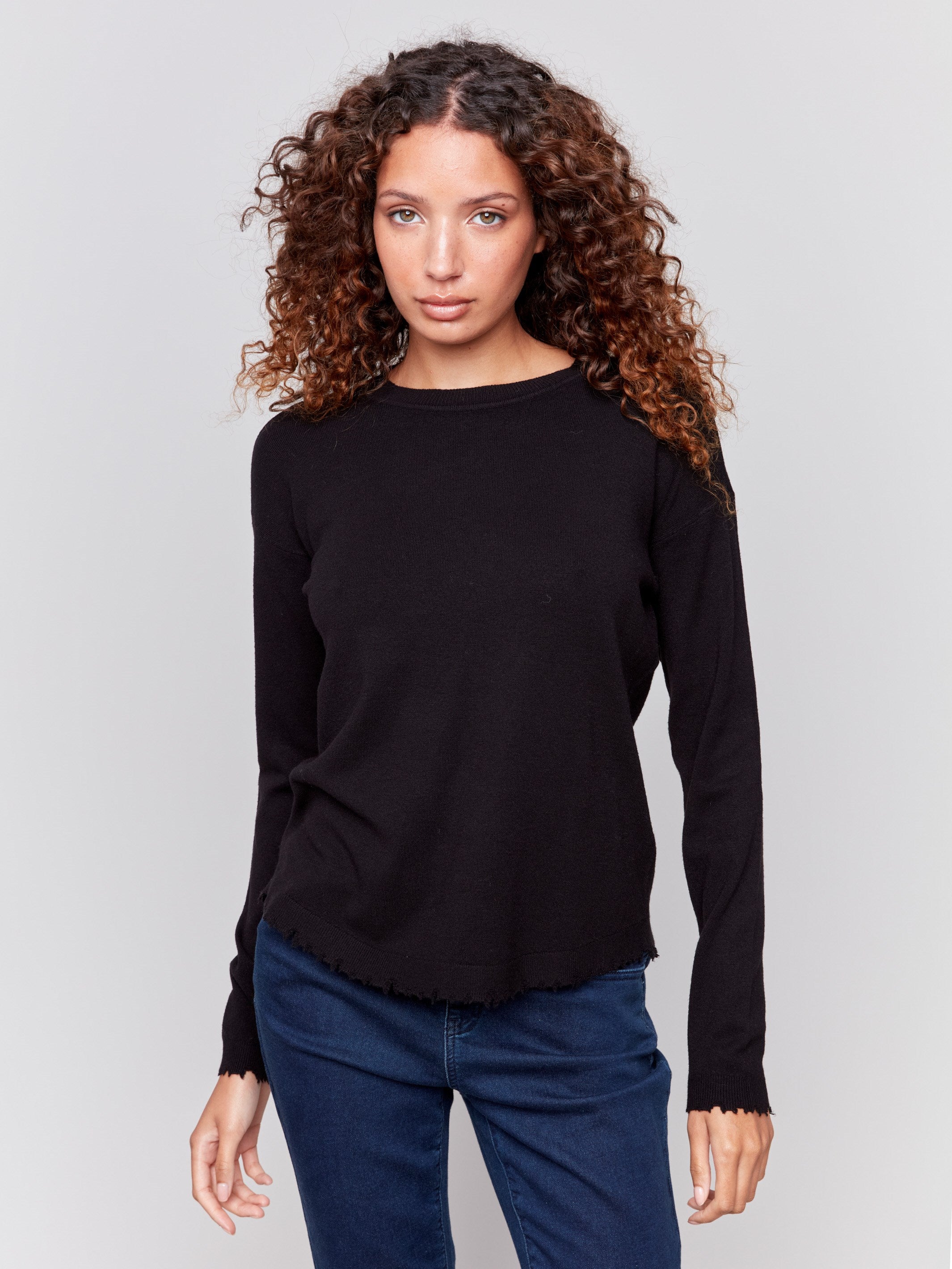 Black long-sleeve sweater with a crew neck and frayed rounded hem by Charlie B.