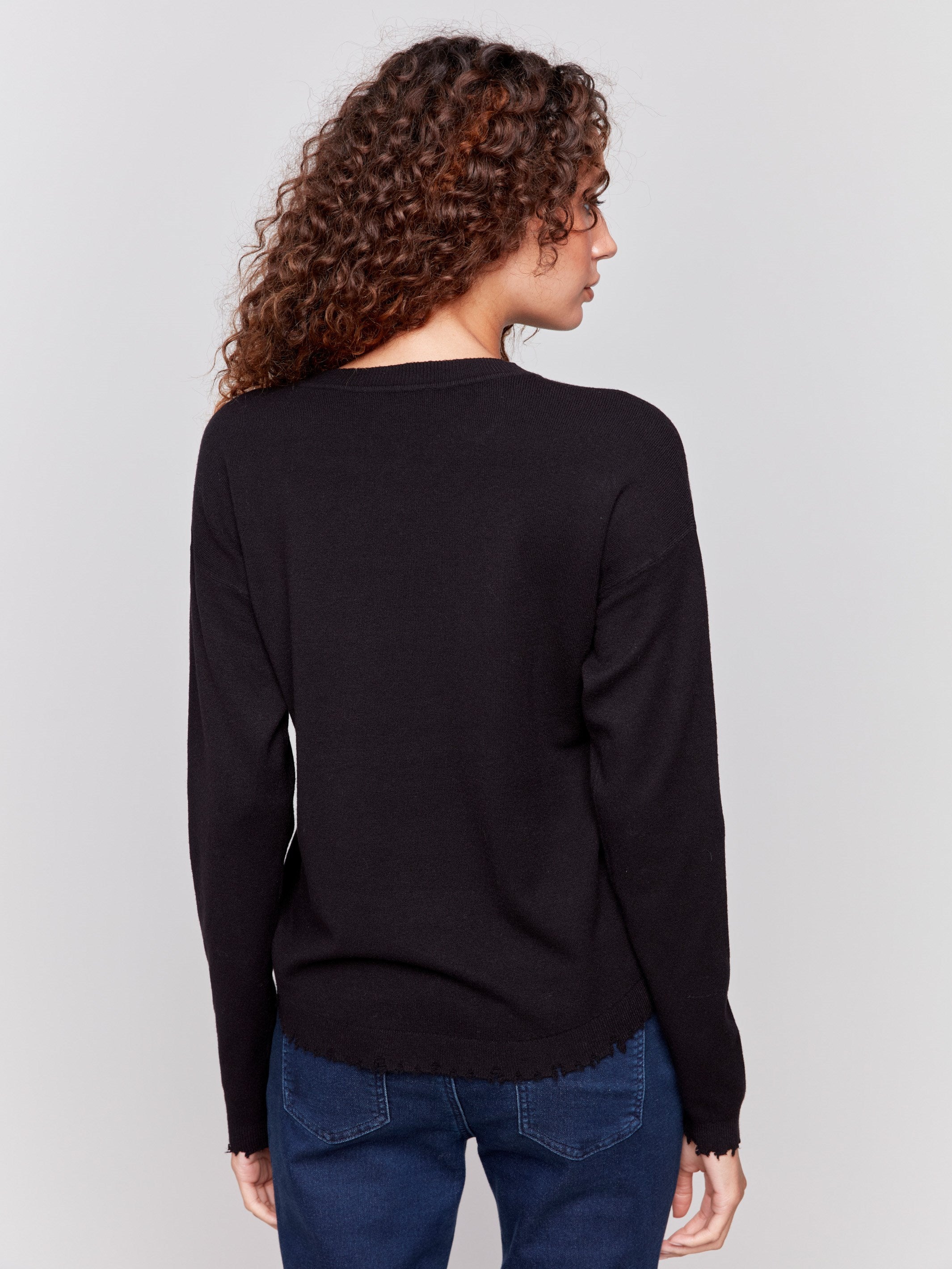 Black long-sleeve sweater with a crew neck and frayed rounded hem by Charlie B.