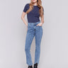 Medium blue denim jeans with a tulip hem and bootcut design by Charlie B. Featuring a mid-rise and frayed hem details.