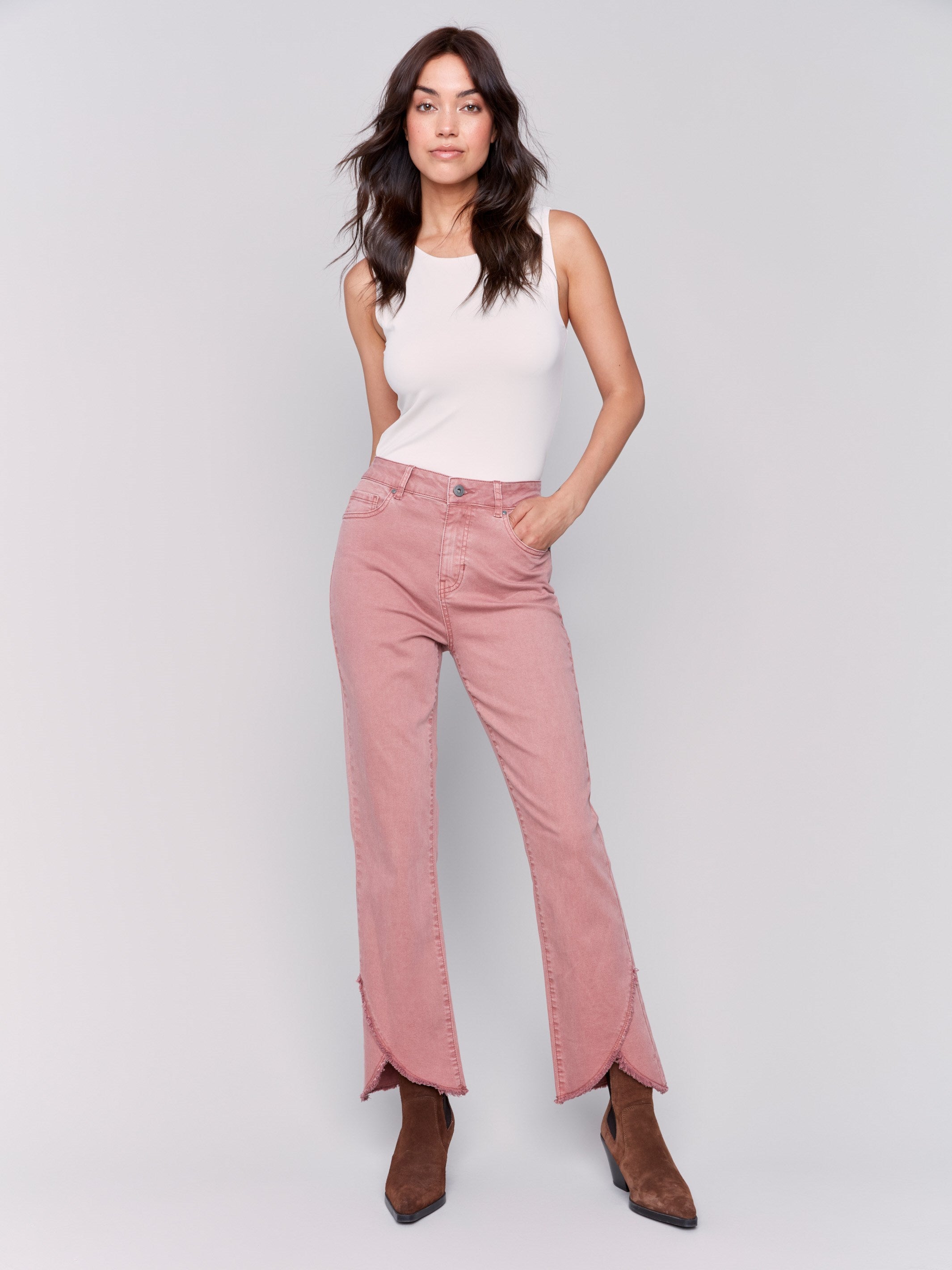 Woodrose pink front tulip hem twill pants featuring a mid-rise and bootcut leg. Unique front tulip hem detail for a stylish look by Charlie B.