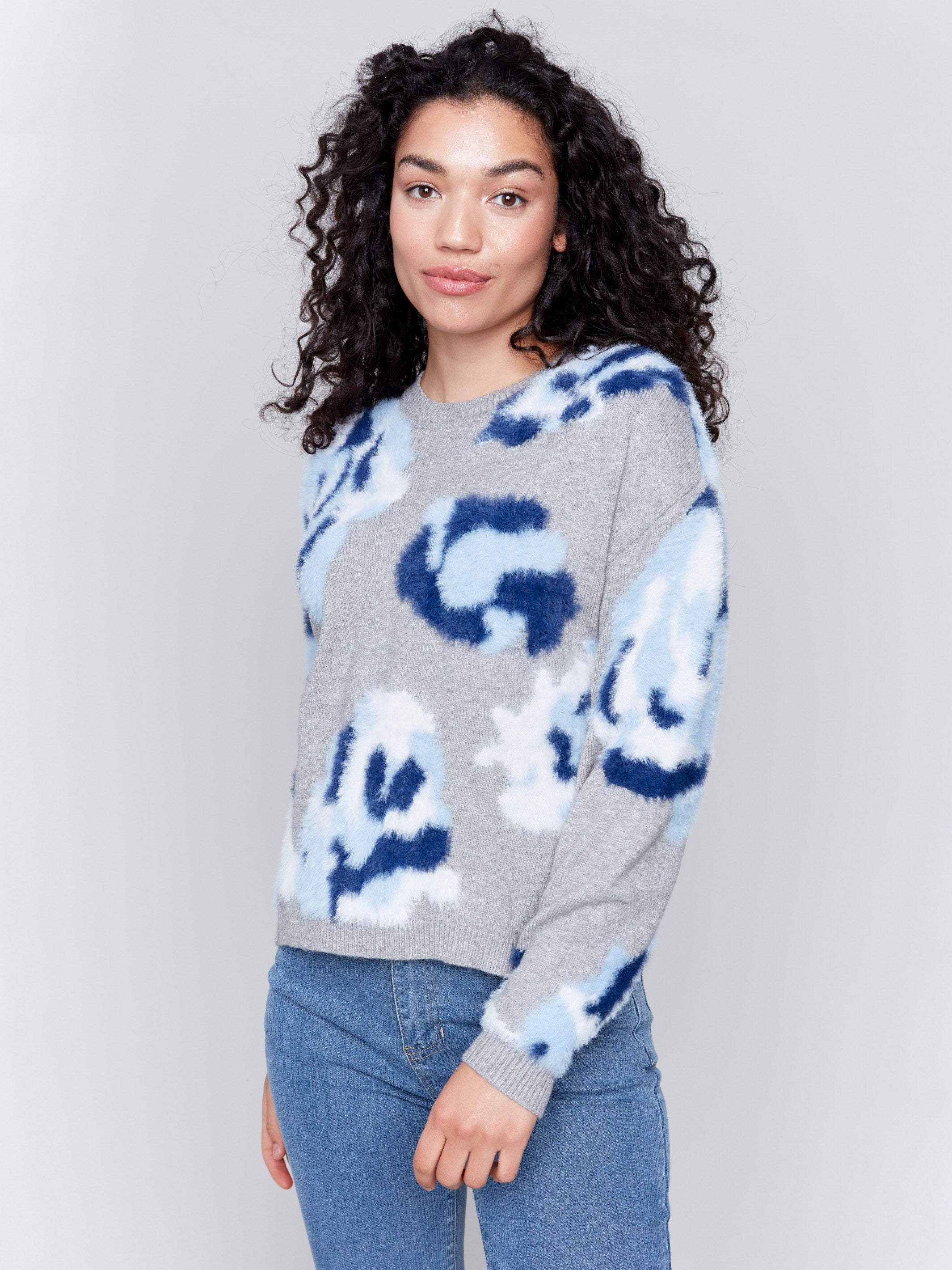 Light grey fuzzy jacquard knit sweater with a floral blue pattern, featuring a crew neck and drop-shoulder design by Charlie B.