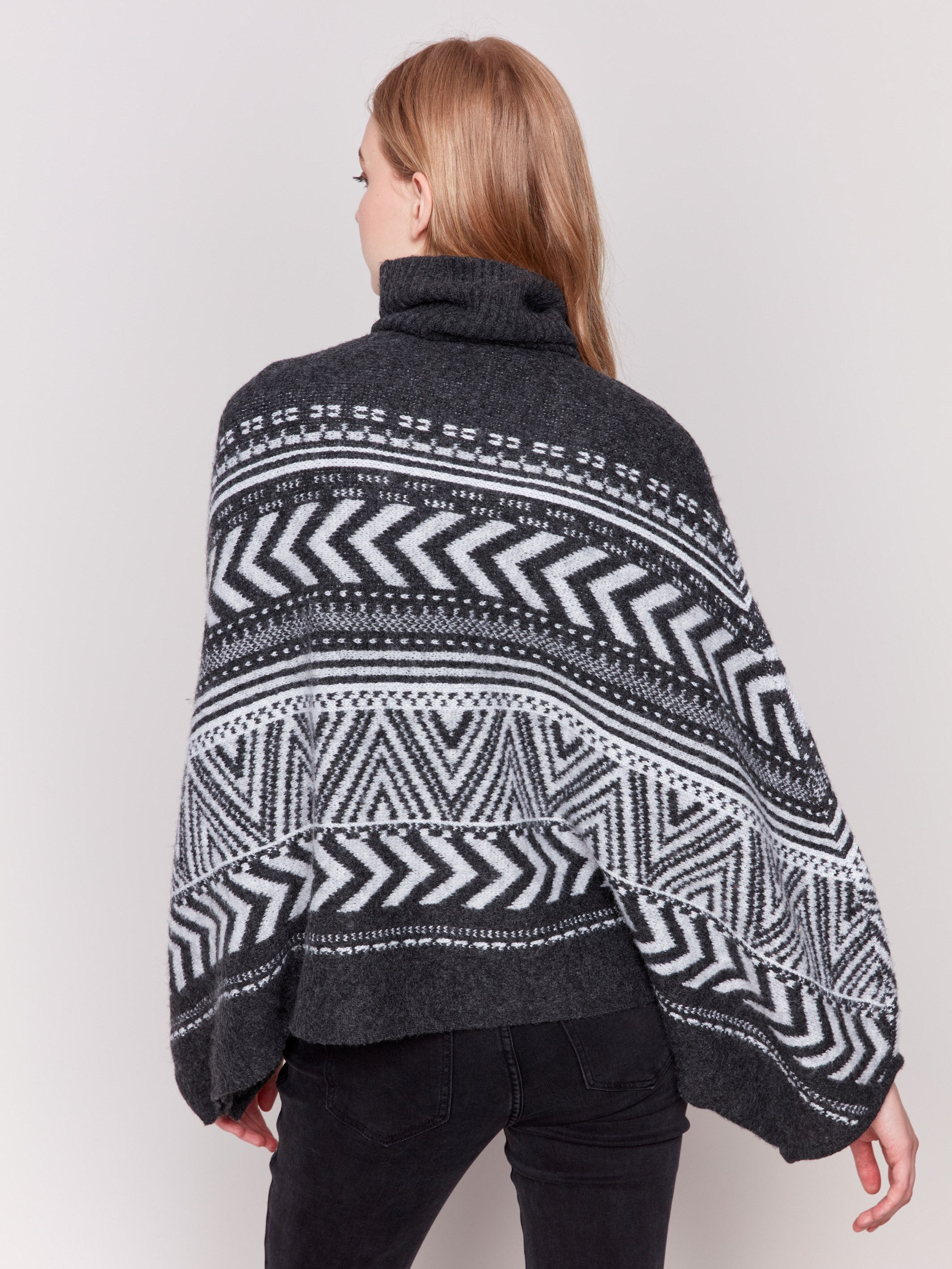 Charcoal poncho with a geometric jacquard pattern, featuring a cozy cowl neck and buttoned sleeves by Charlie B.