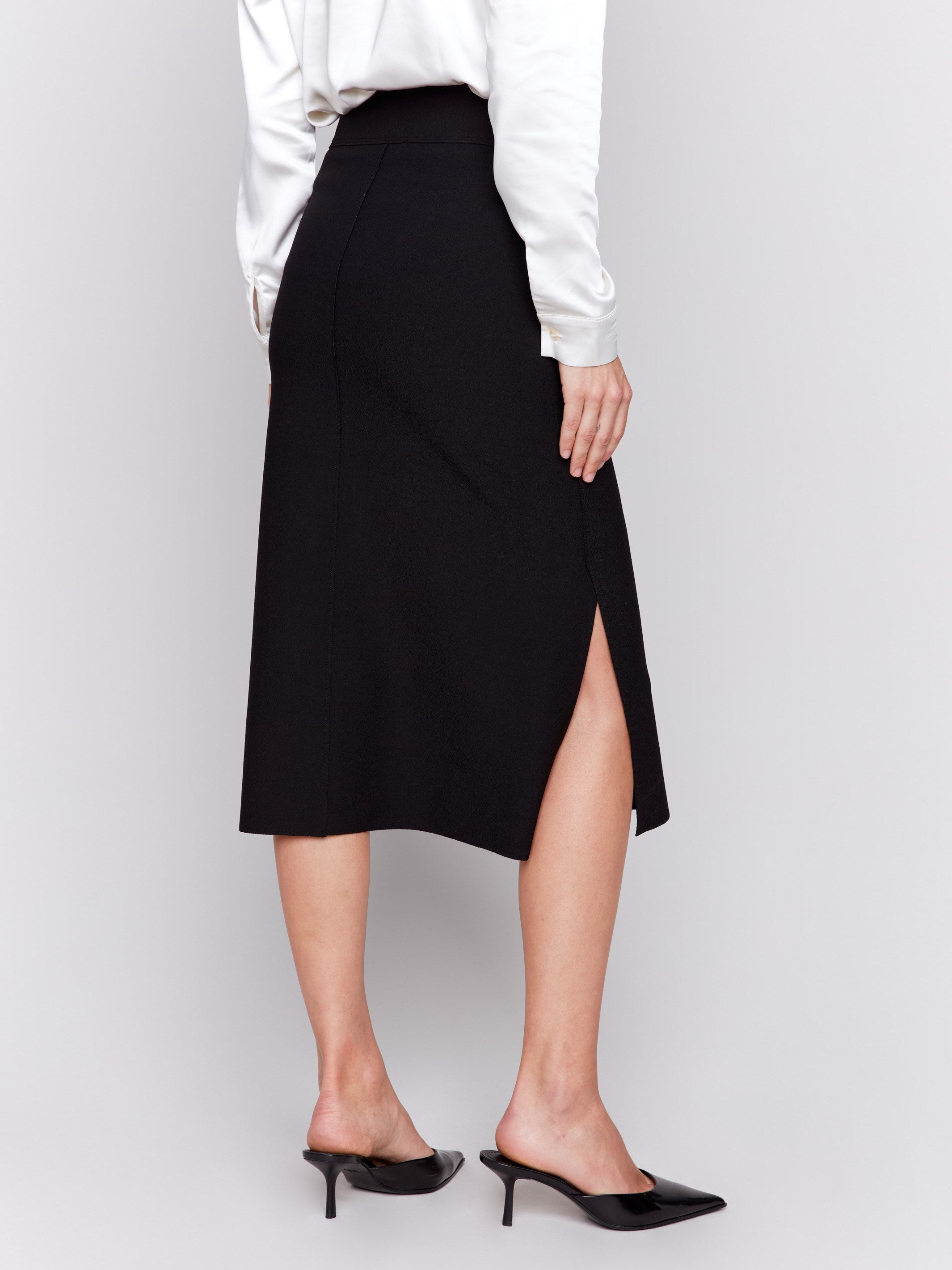 Elegant black gutsy crepe midi skirt with front patch pockets, featuring a side slit and a sleek, polished look by Charlie B.