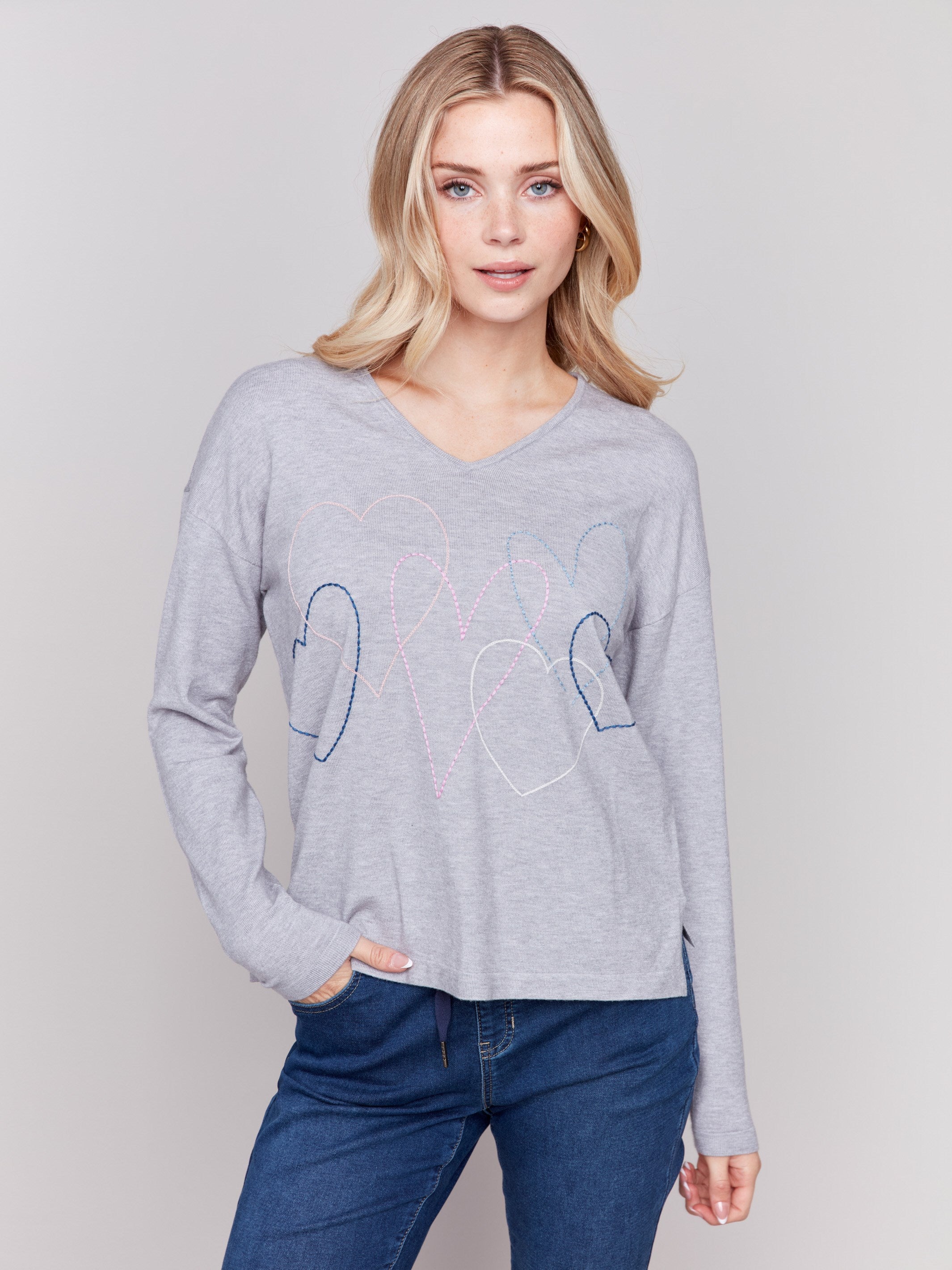 Light grey v-neck sweater with heart stitch design, featuring long sleeves and a relaxed fit by Charlie B.