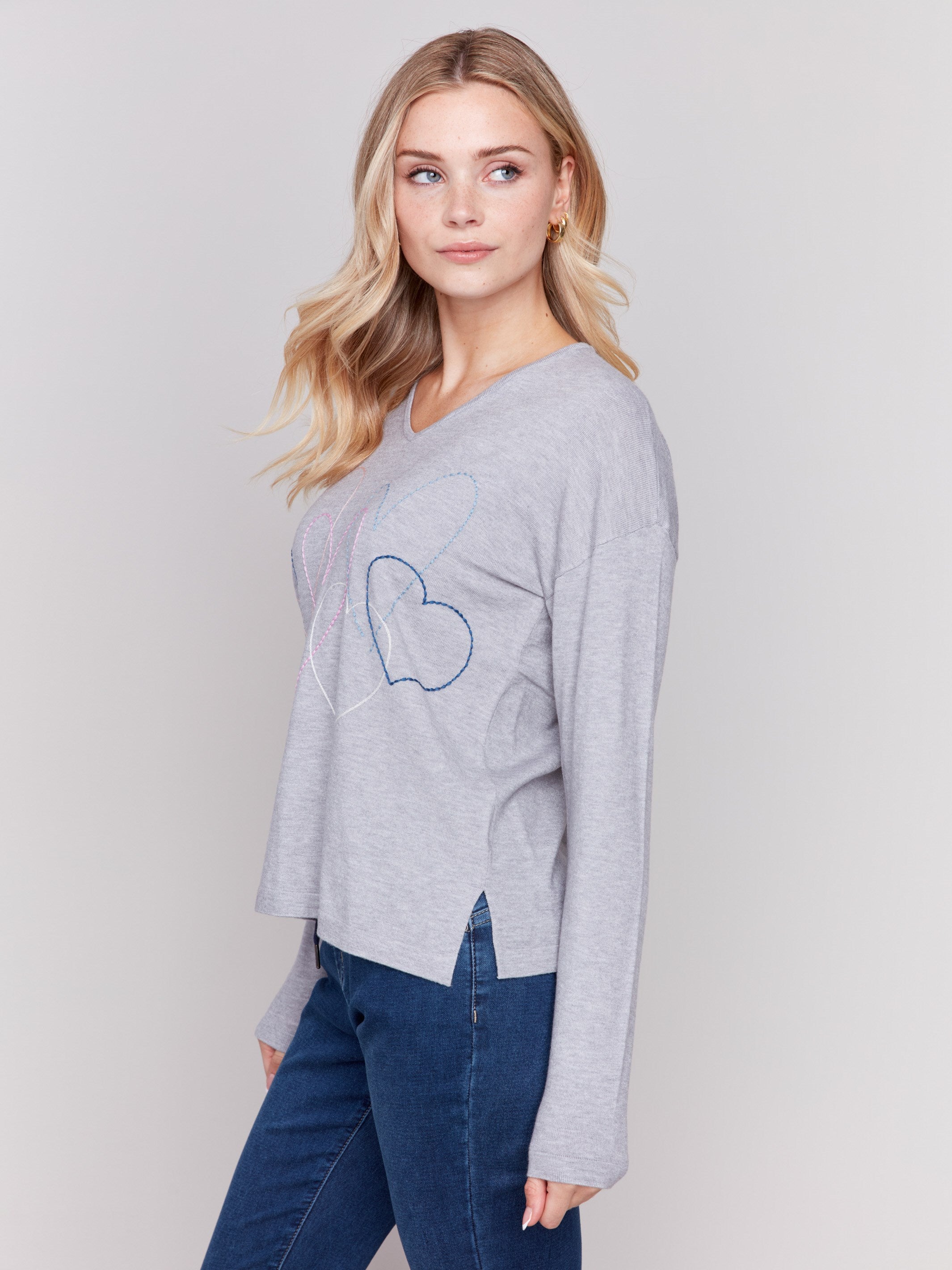 Light grey v-neck sweater with heart stitch design, featuring long sleeves and a relaxed fit by Charlie B.