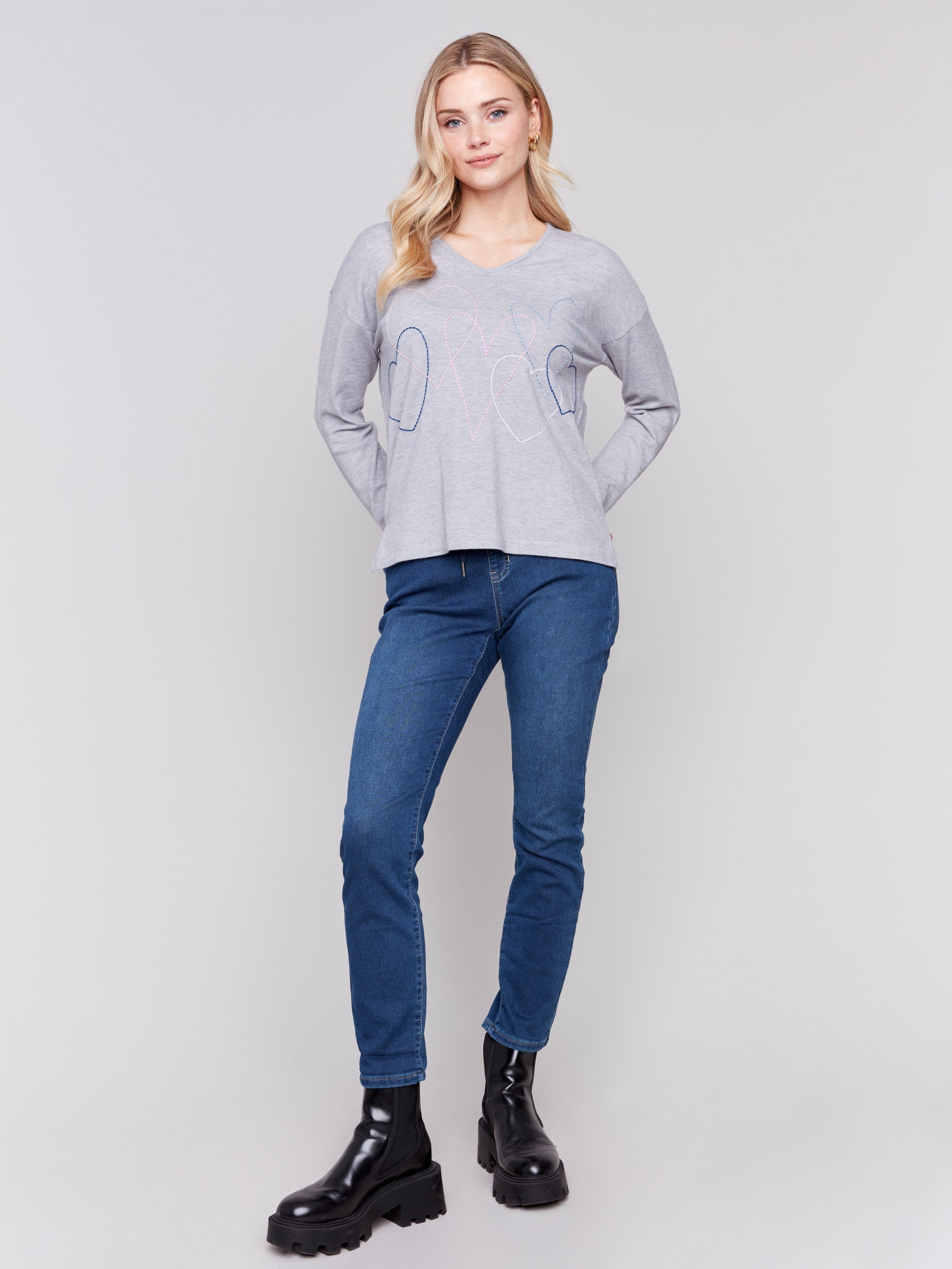 Light grey v-neck sweater with heart stitch design, featuring long sleeves and a relaxed fit by Charlie B.