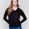 Black v-neck sweater with heart stitch design, featuring long sleeves and a relaxed fit by Charlie B.