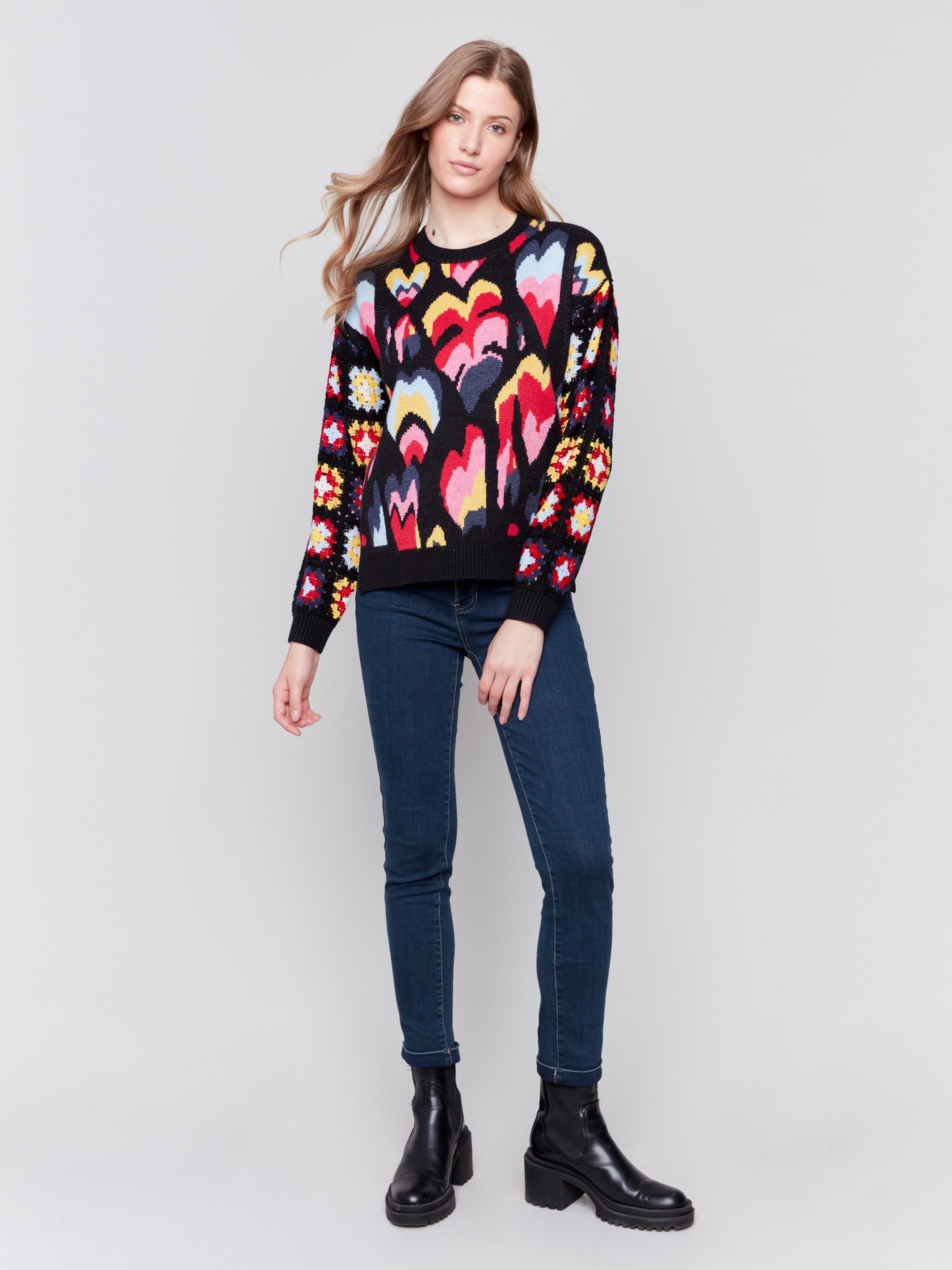 Black jacquard sweater with colorful pattern, featuring crochet sleeves and ribbed cuffs by Charlie B.