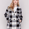 Women's plaid coat in black and white with a lapel notch collar, full button closure, and side welt pockets by Charlie B.