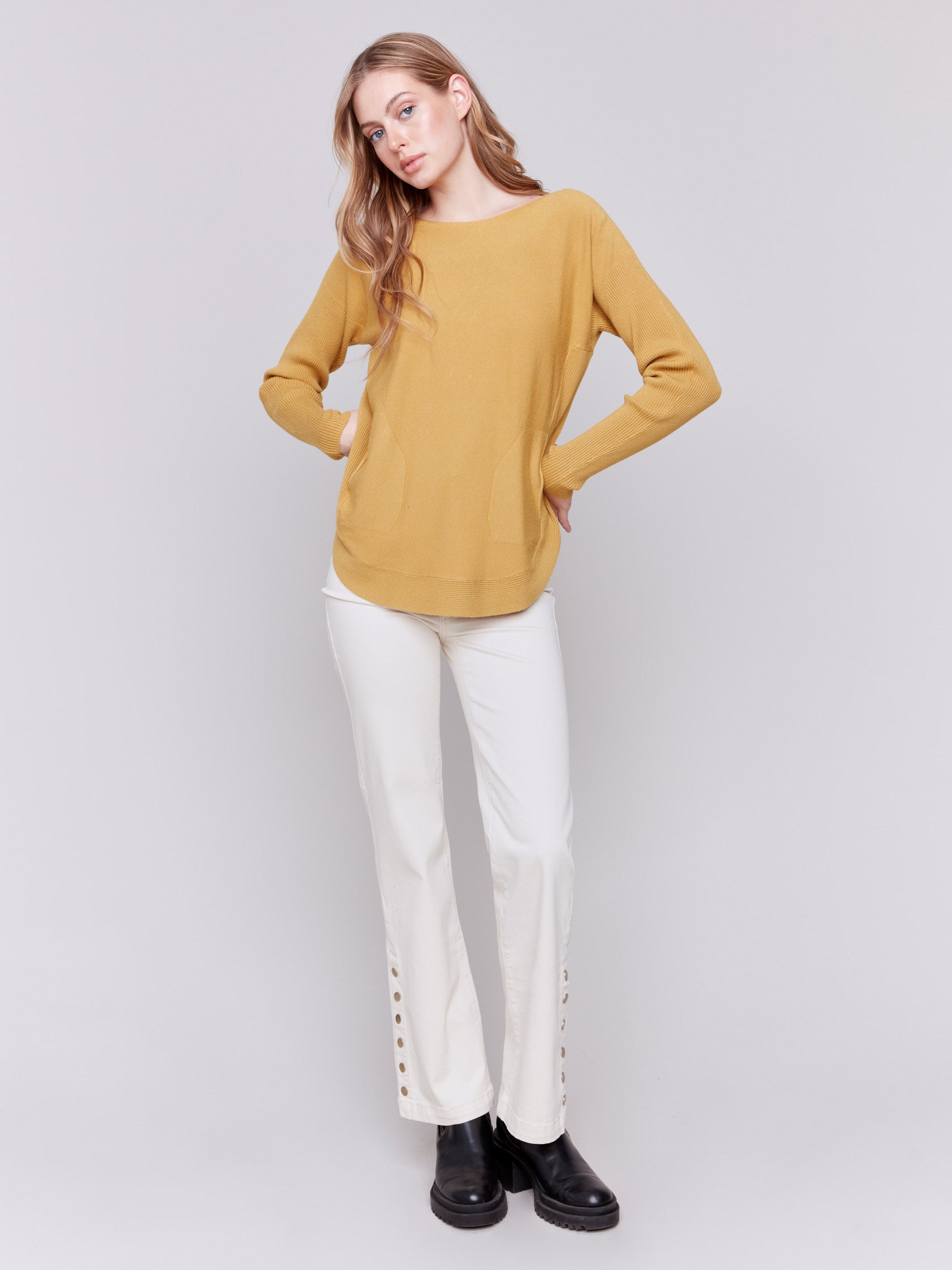 Amber yellow knit sweater with a crew neckline, long ribbed sleeves, and back lace-up eyelet details by Charlie B.