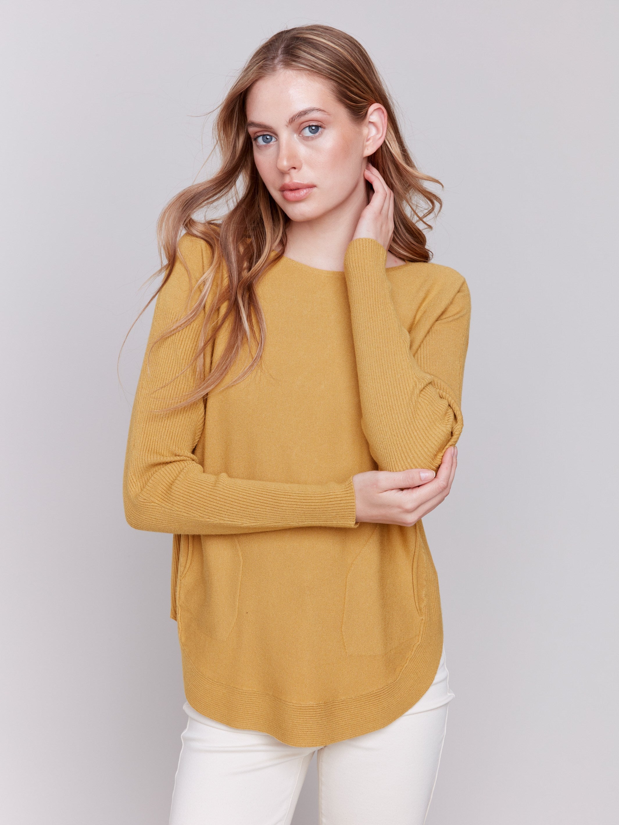 Amber yellow knit sweater with a crew neckline, long ribbed sleeves, and back lace-up eyelet details by Charlie B.