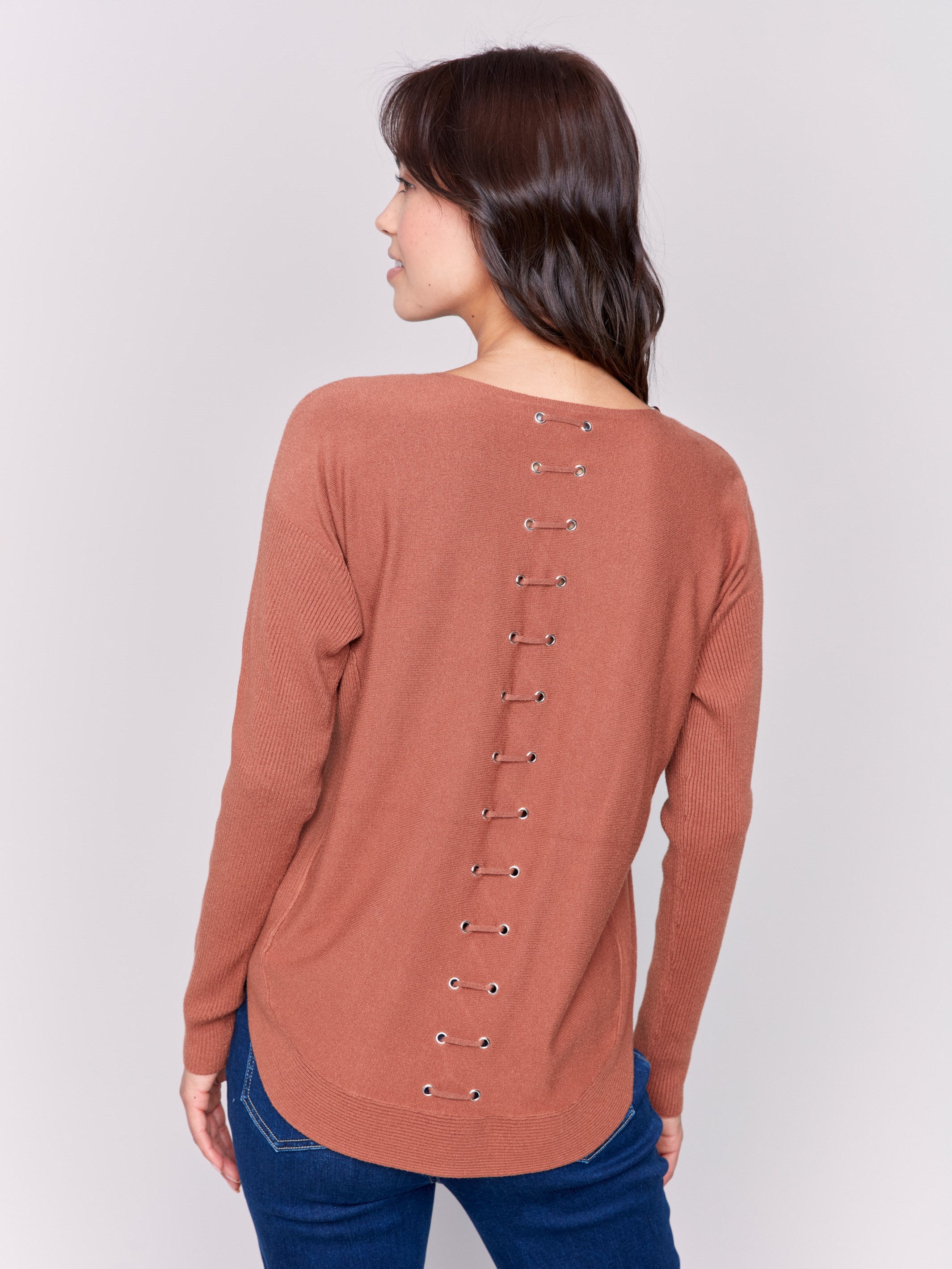 Terracotta knit sweater with a crew neckline, long ribbed sleeves, and back lace-up eyelet details by Charlie B.