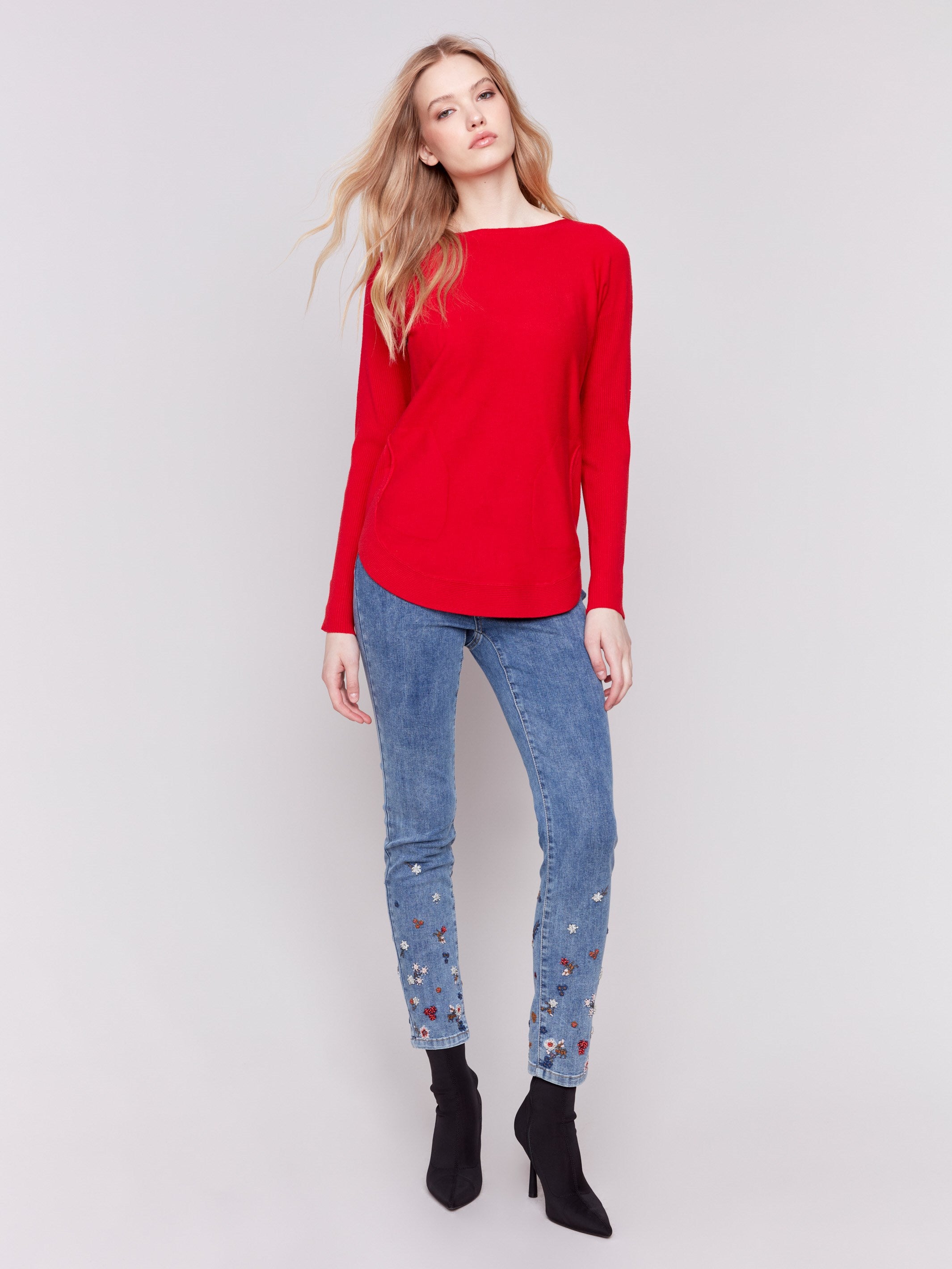 Cranberry red long-sleeved knit sweater with lace-up cuffs, rounded hem, and front pockets by Charlie B.