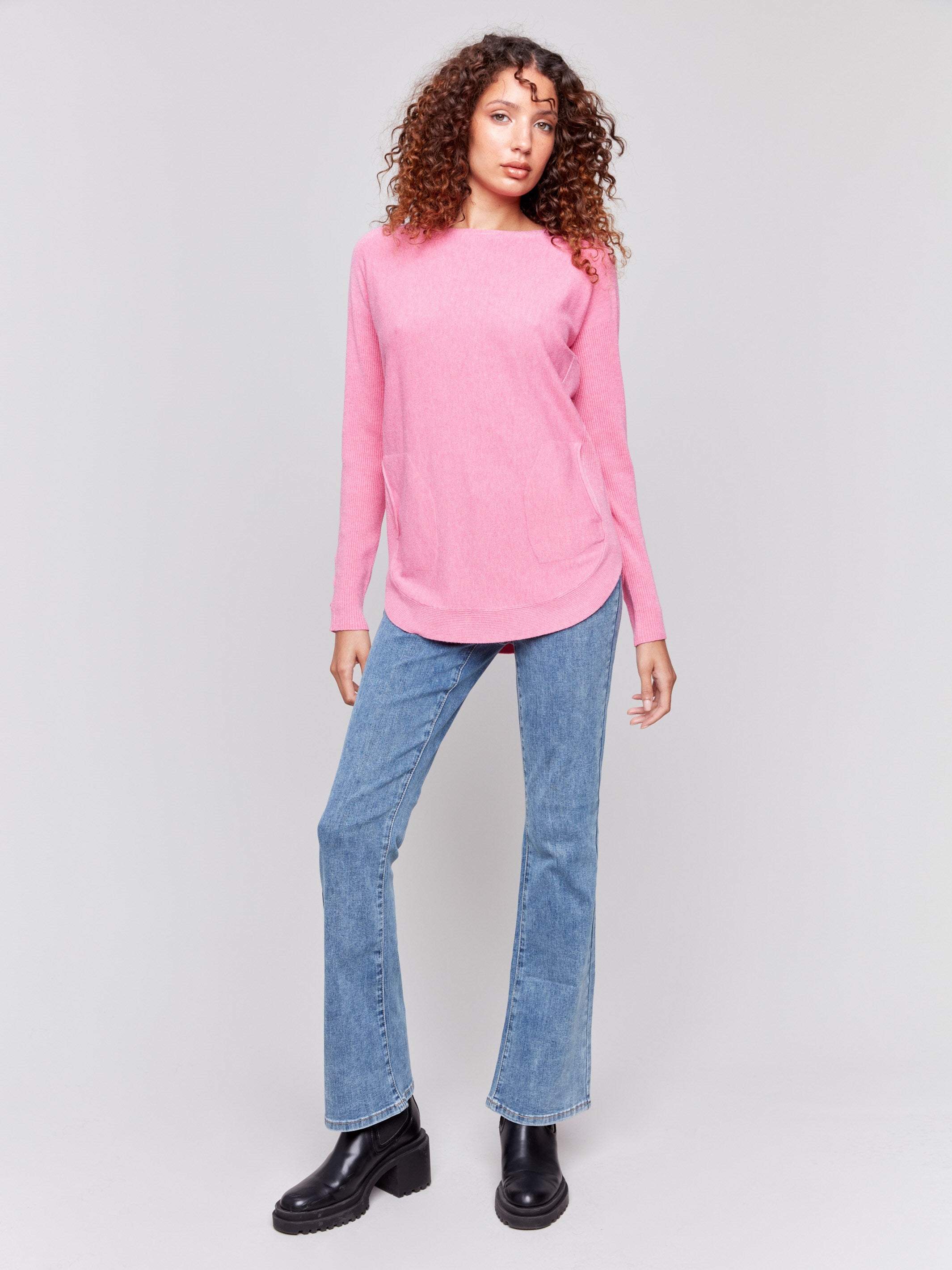 Magenta pink long-sleeved knit sweater with lace-up cuffs, rounded hem, and front pockets by Charlie B.