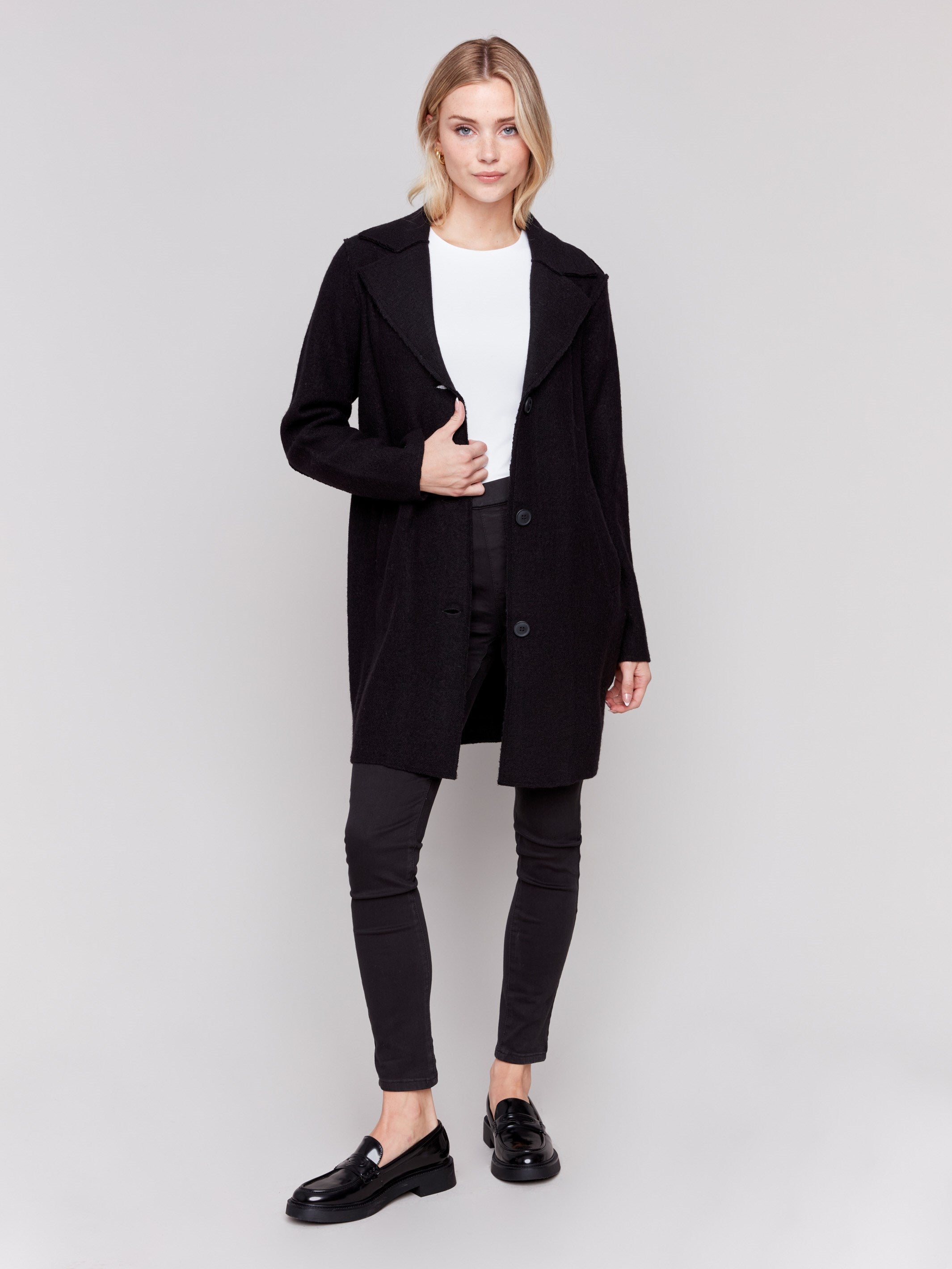 Black long wool coat with lapel notch collar and button closures, featuring front welt pockets by Charlie B.