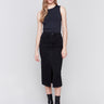 Charcoal black midi-length denim skirt with front slit, featuring a mid-rise waist and slim fit, paired with boots by Charlie B.